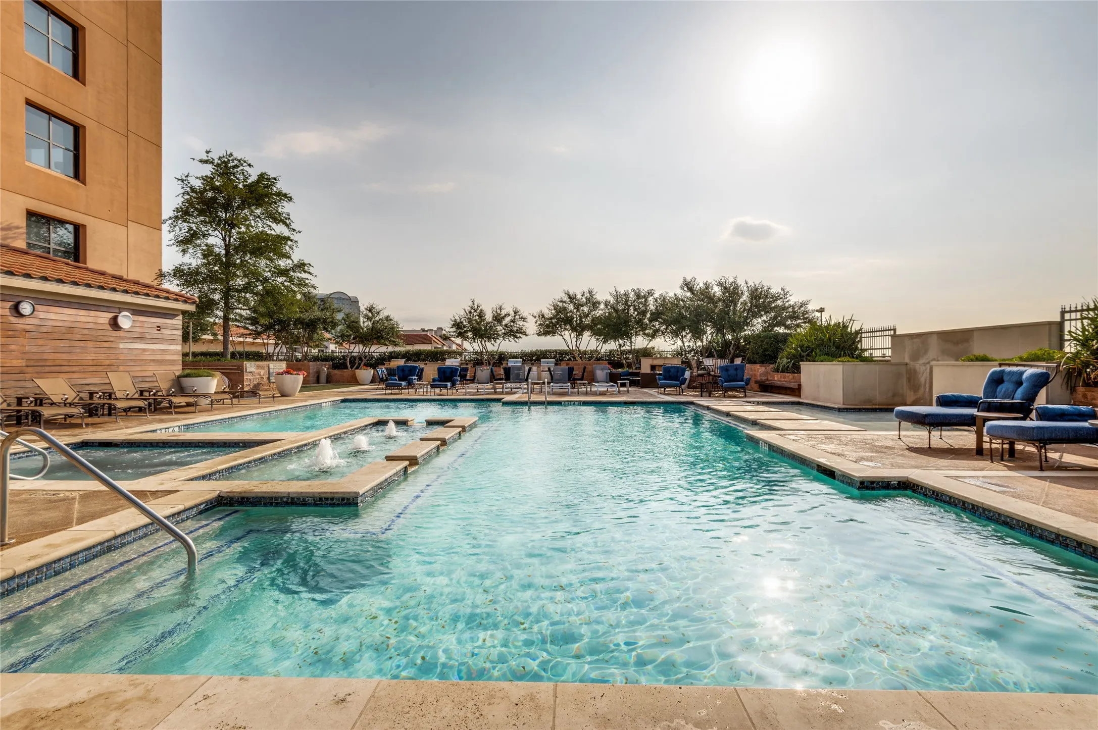 Resort-style pool area featuring multiple water features, integrated spa, and extensive surrounding decking