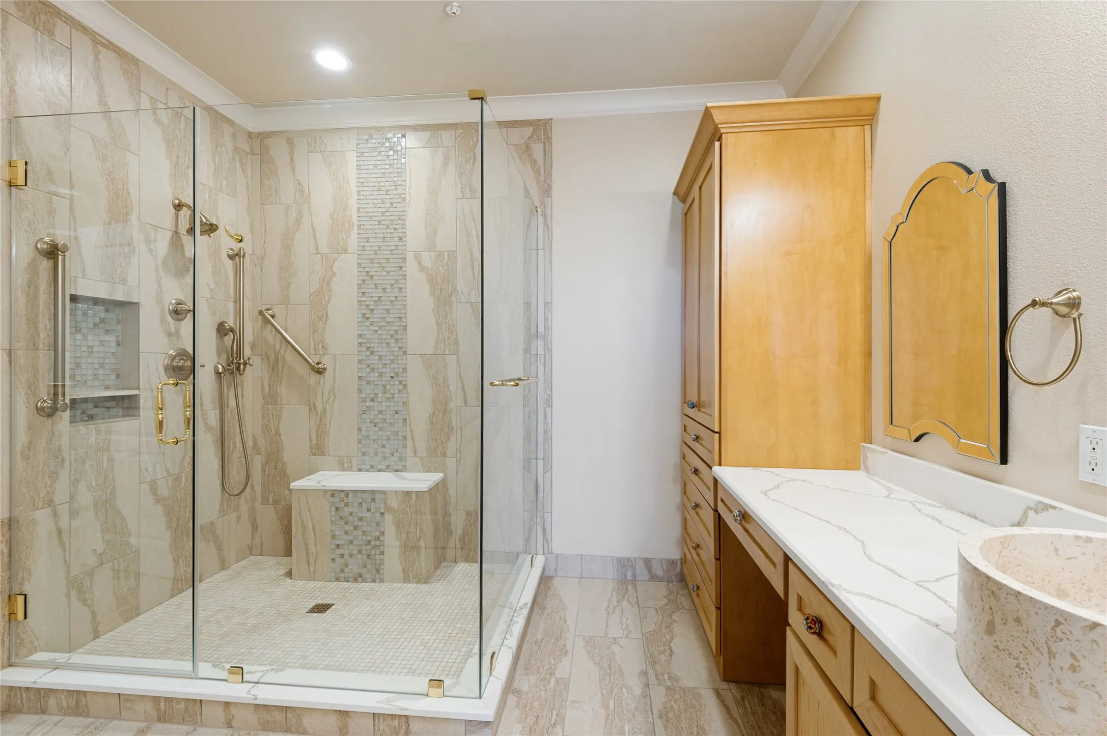 Spacious bathroom featuring a glass-enclosed shower with a built-in bench and multiple shower heads