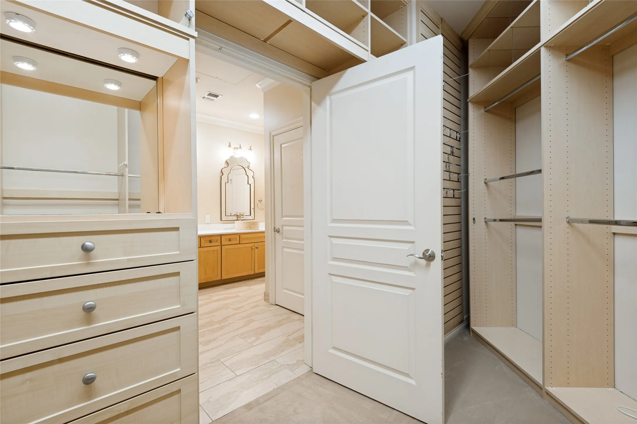 Custom closet system featuring built-in drawers, shelving, and hanging rods