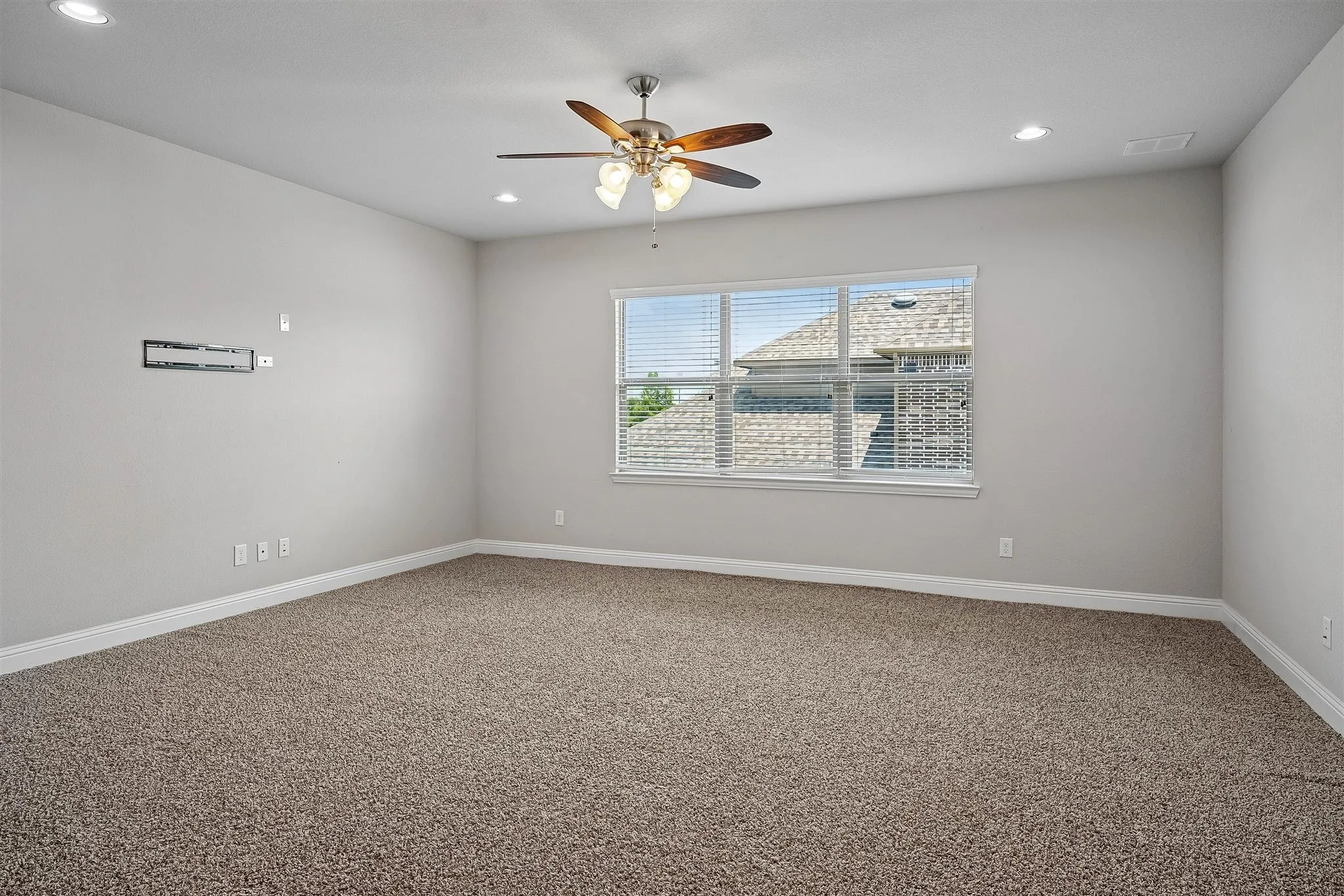 Carpeted room featuring a ceiling fan with light fixture, recessed lighting, and a window with blinds
