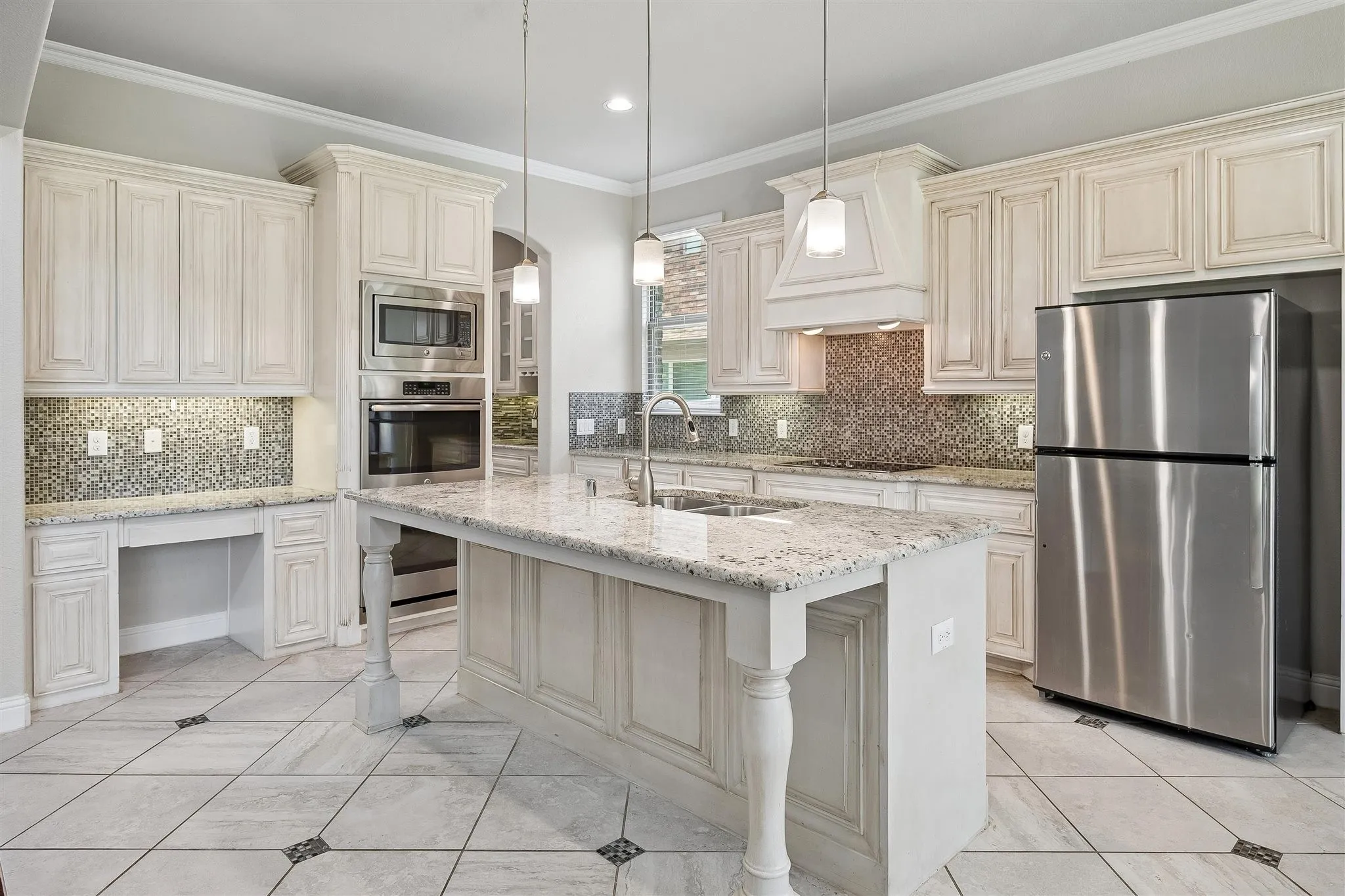 Kitchen featuring a central island with granite countertop, integrated sink, and pendant lighting