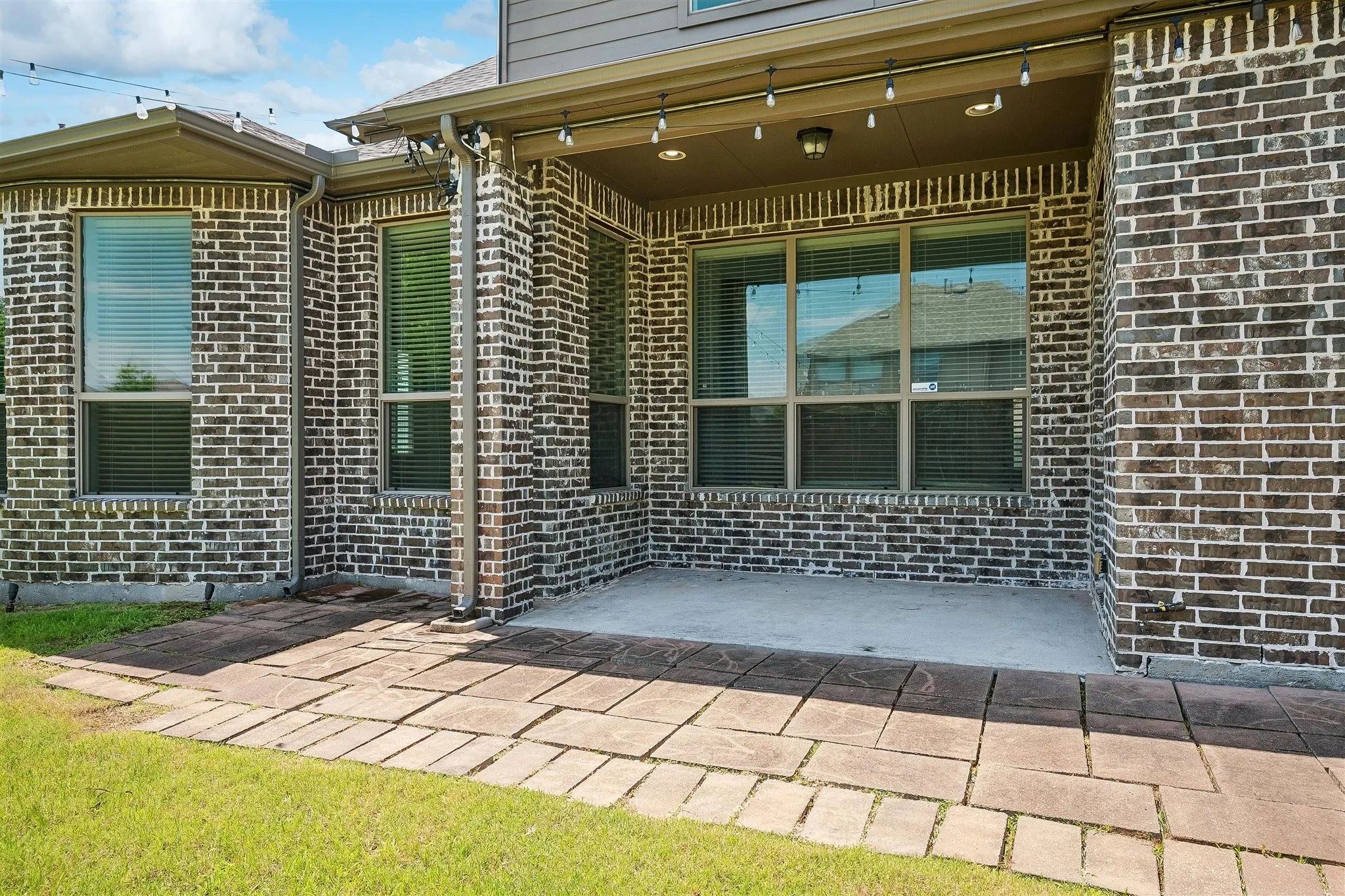 Covered patio featuring a concrete slab and string lighting