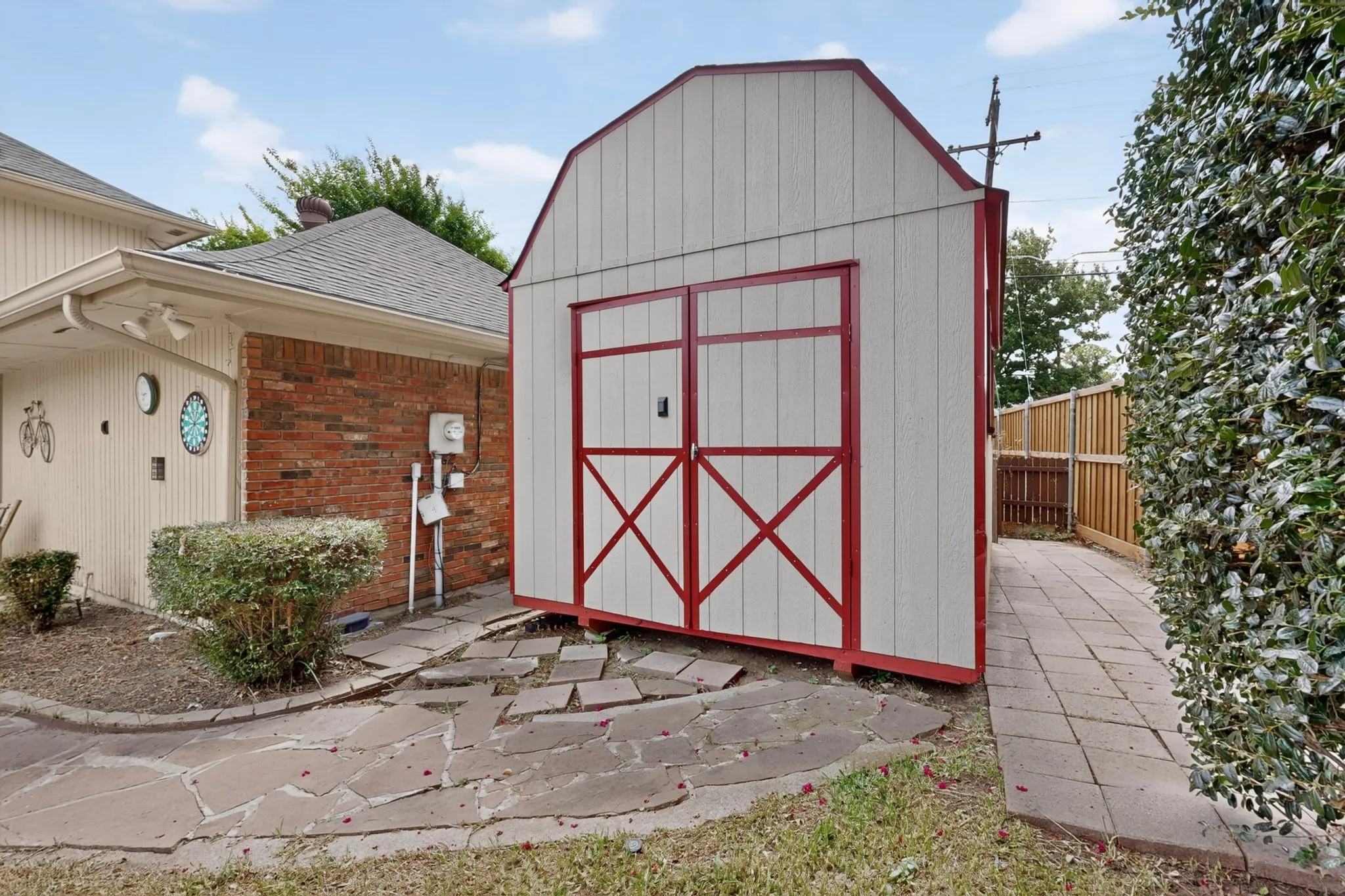 Barn-style storage shed with double doors and red trim