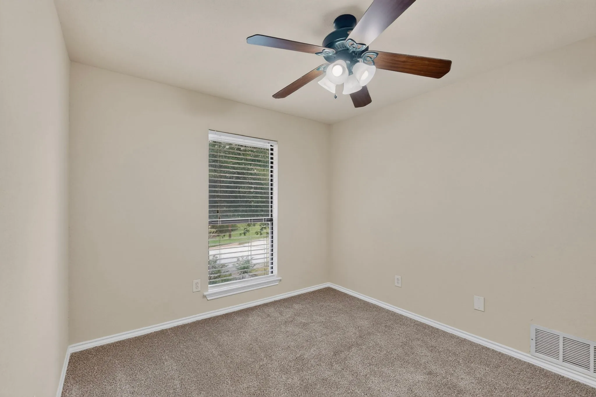 Room featuring neutral wall tones, textured carpeting, and white baseboards