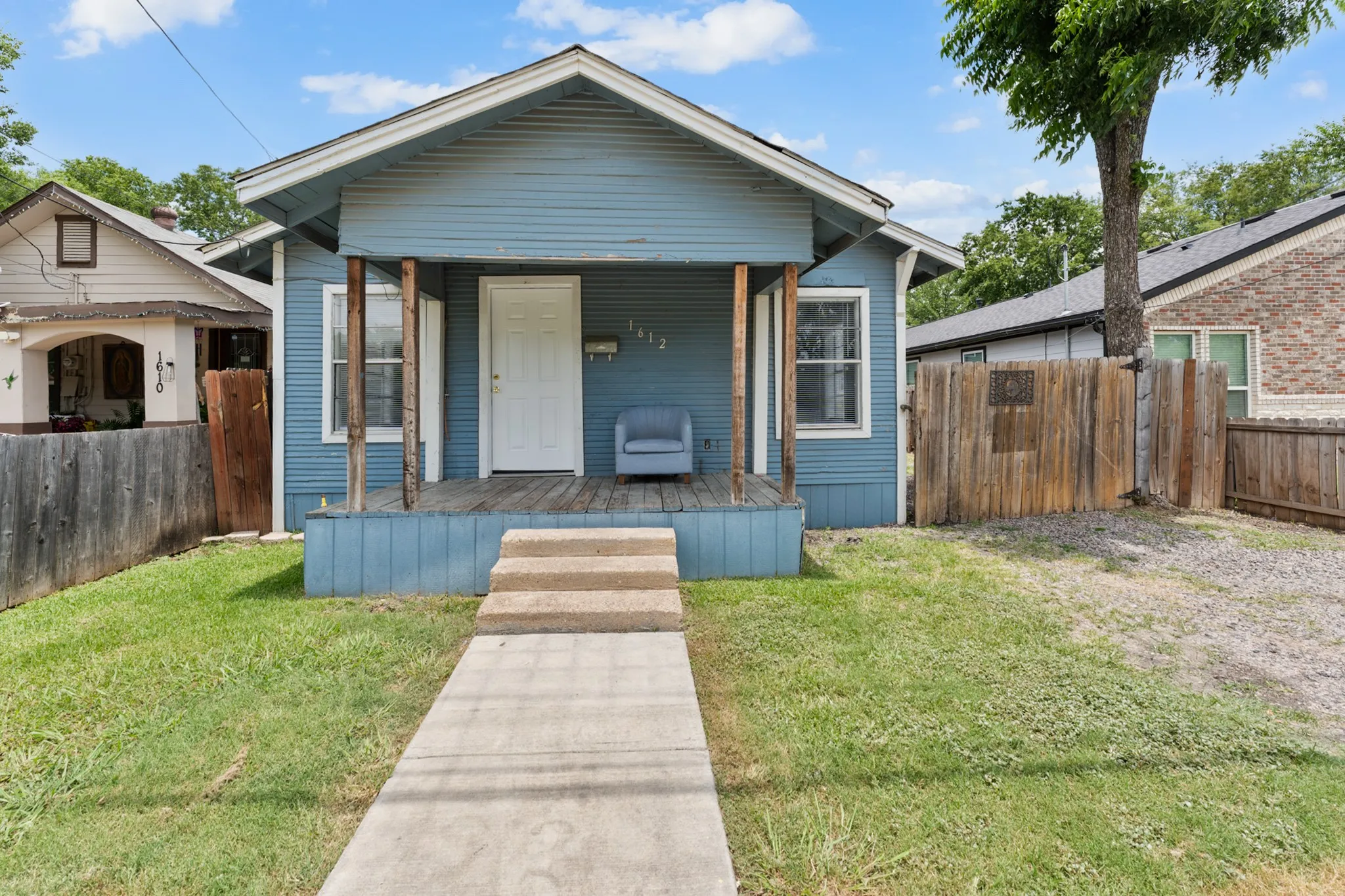 Blue siding exterior with a covered front porch featuring a white entry door