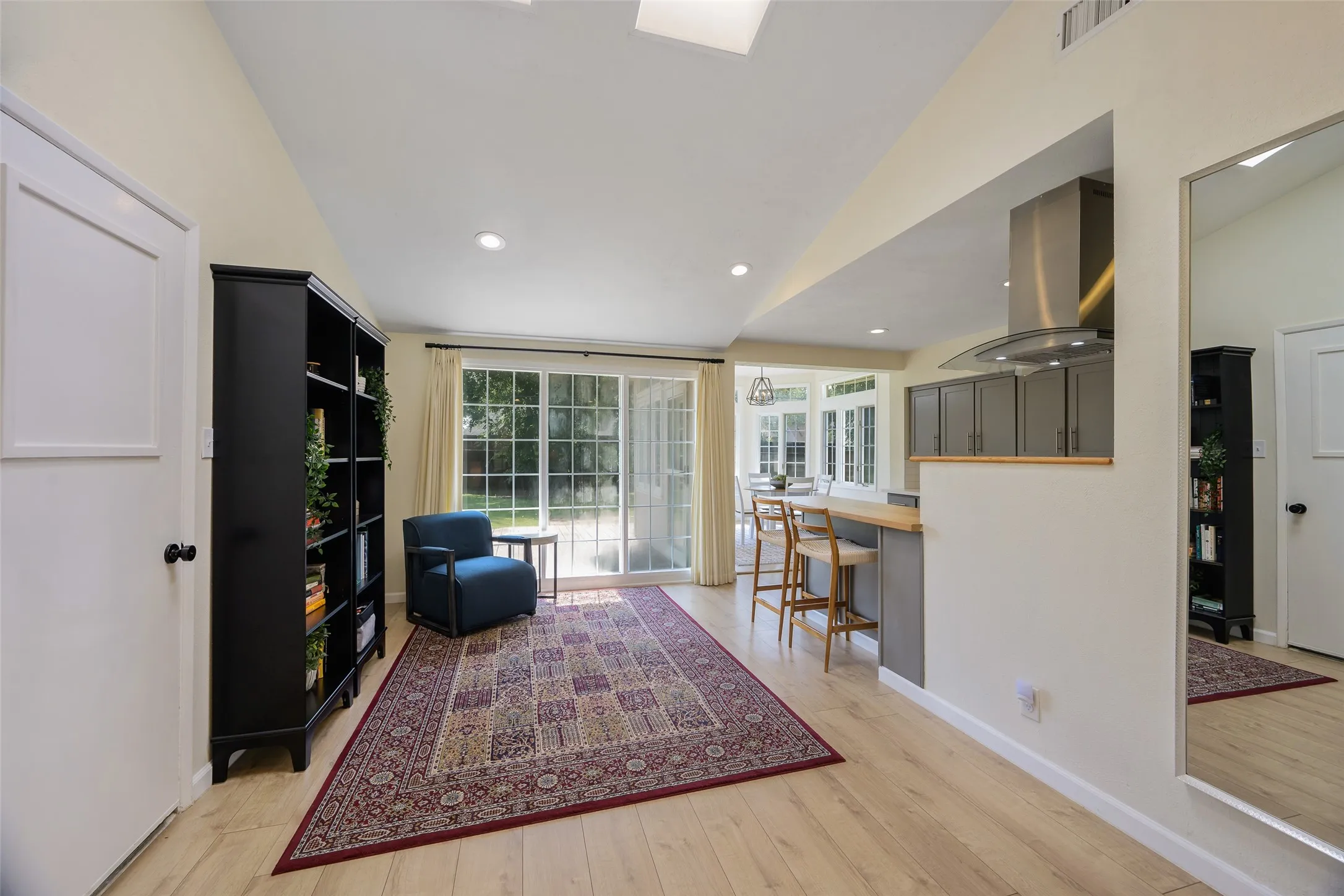 Spacious room with wood-finish flooring, vaulted ceiling, and recessed lighting