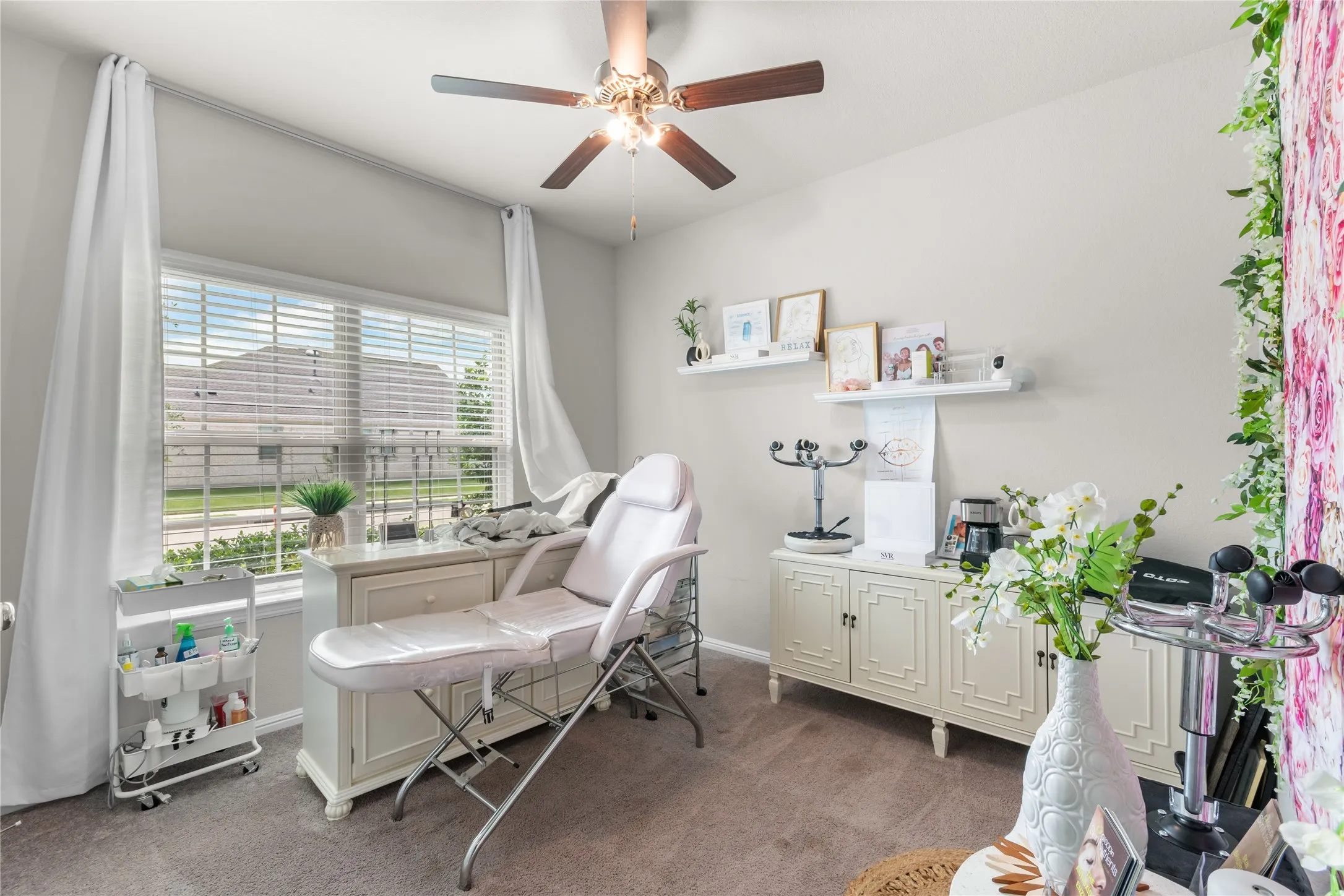 Spacious room featuring a ceiling fan with light fixture, neutral wall paint, and carpet flooring