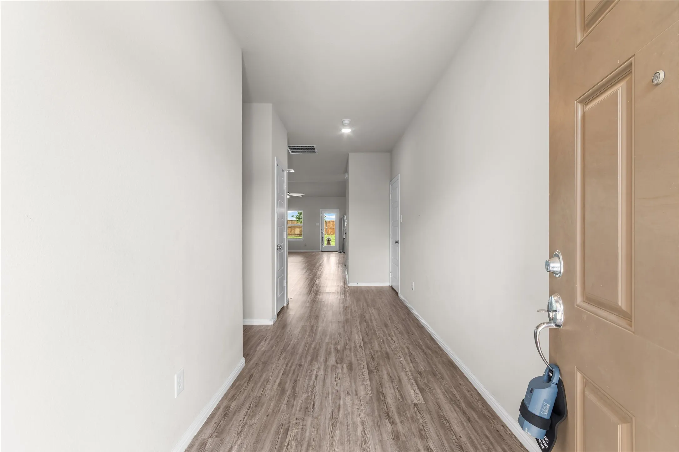 Entryway featuring wood-finish flooring, recessed lighting, white baseboards, and a neutral color palette