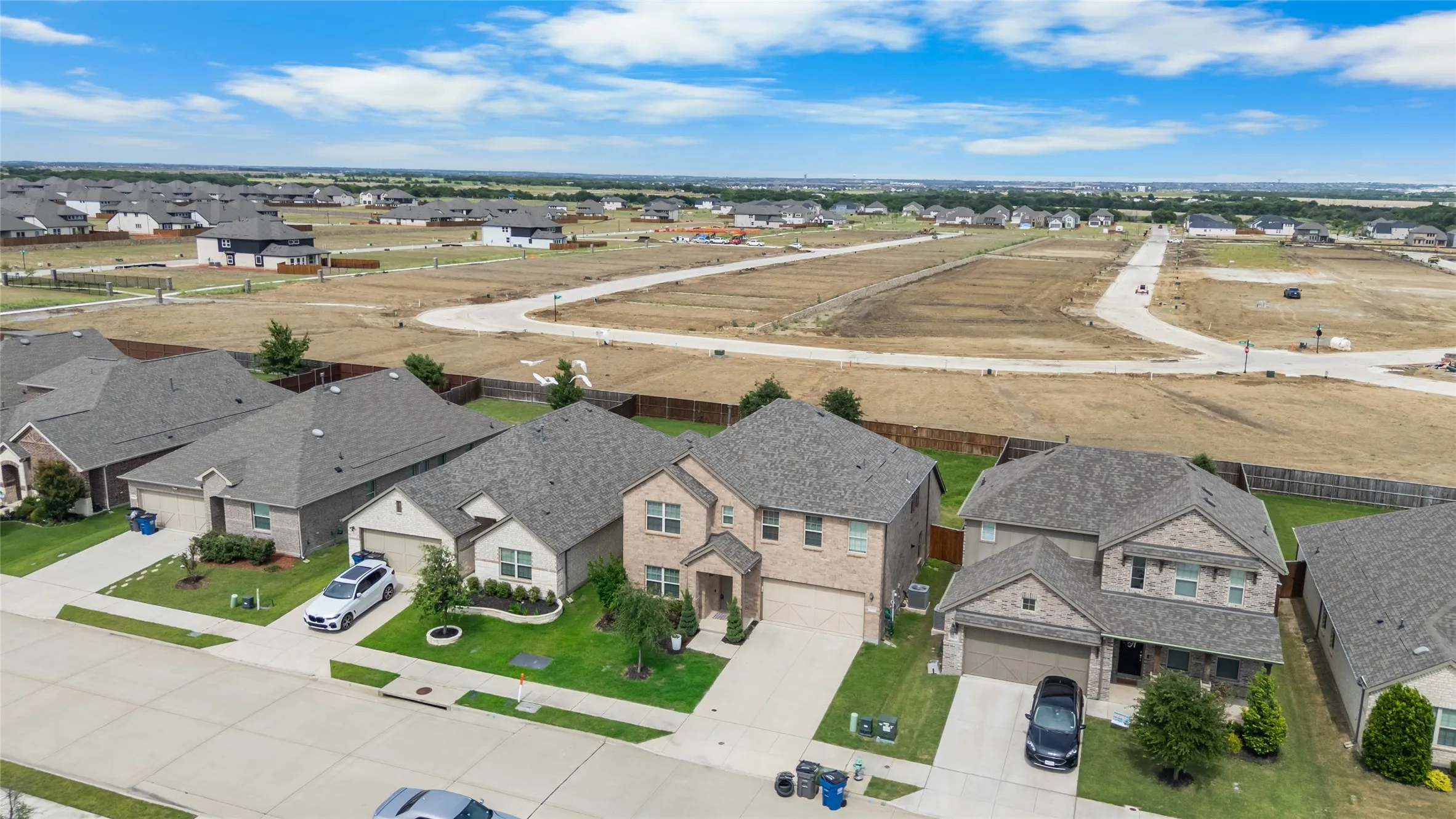 Suburban residential street featuring multiple single-family homes with pitched roofs and attached garages