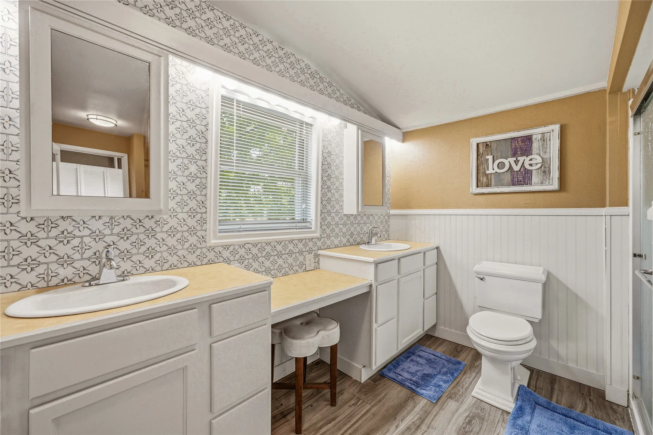 Dual vanity featuring white cabinetry, light countertops, and individual mirrors