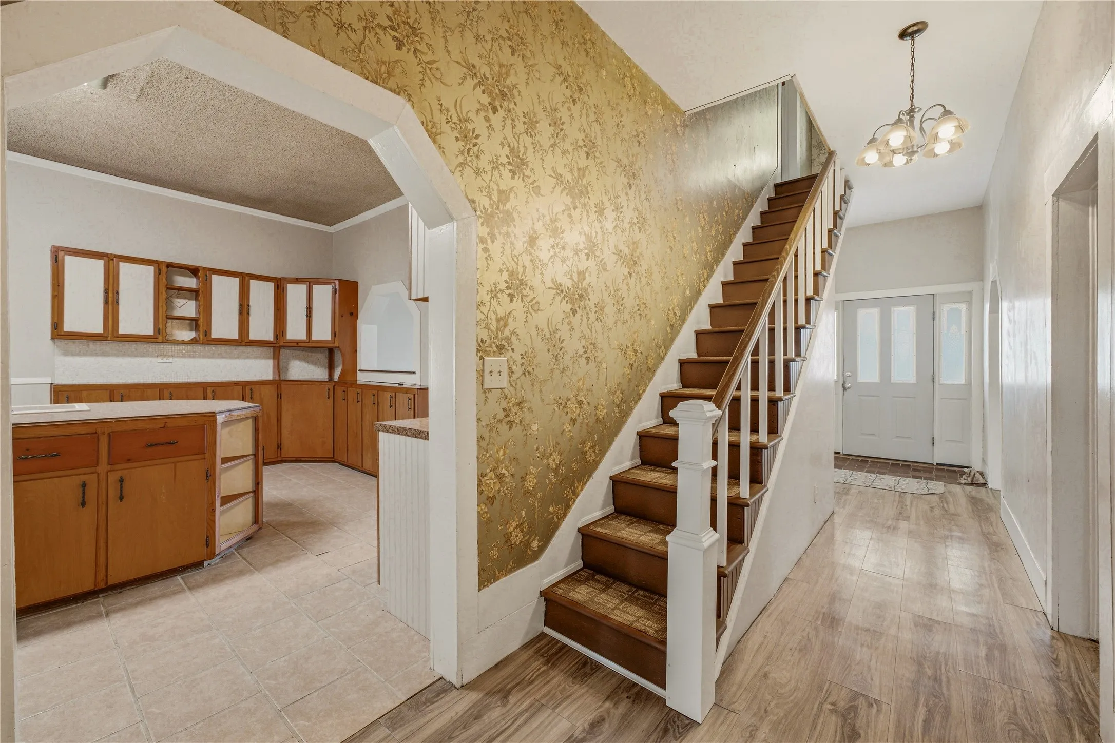 Entryway featuring wood-finish flooring, a staircase with white spindles, and a multi-pane front door with sidelights