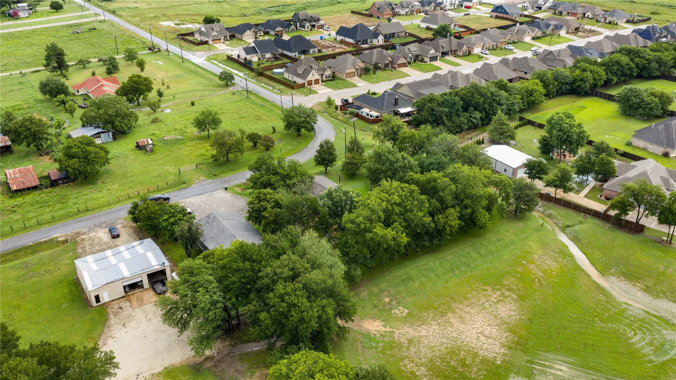 Expansive green landscape featuring mature trees and a residential neighborhood