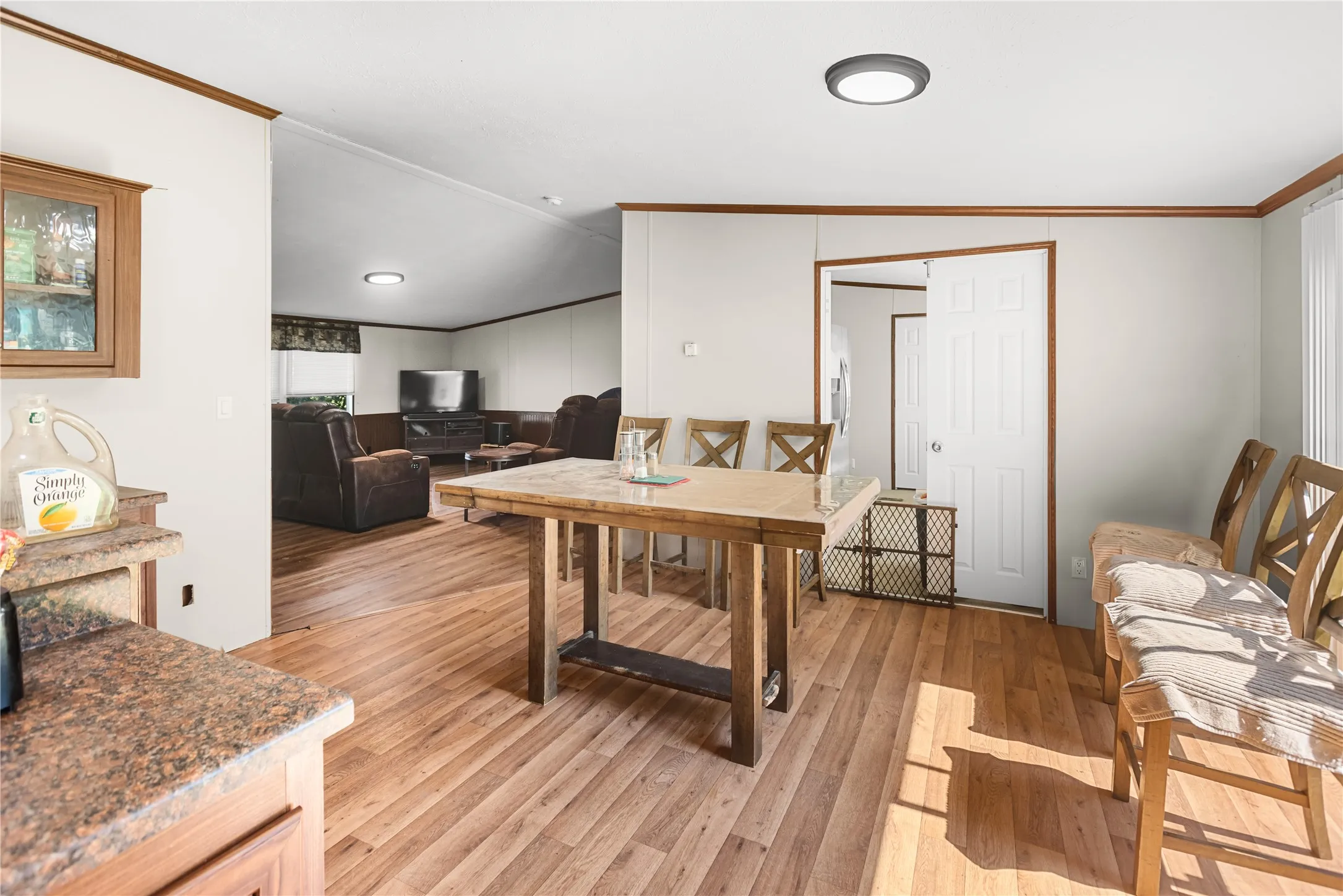 Wood-finish flooring extends throughout the space, complemented by neutral wall tones and dark trim accents