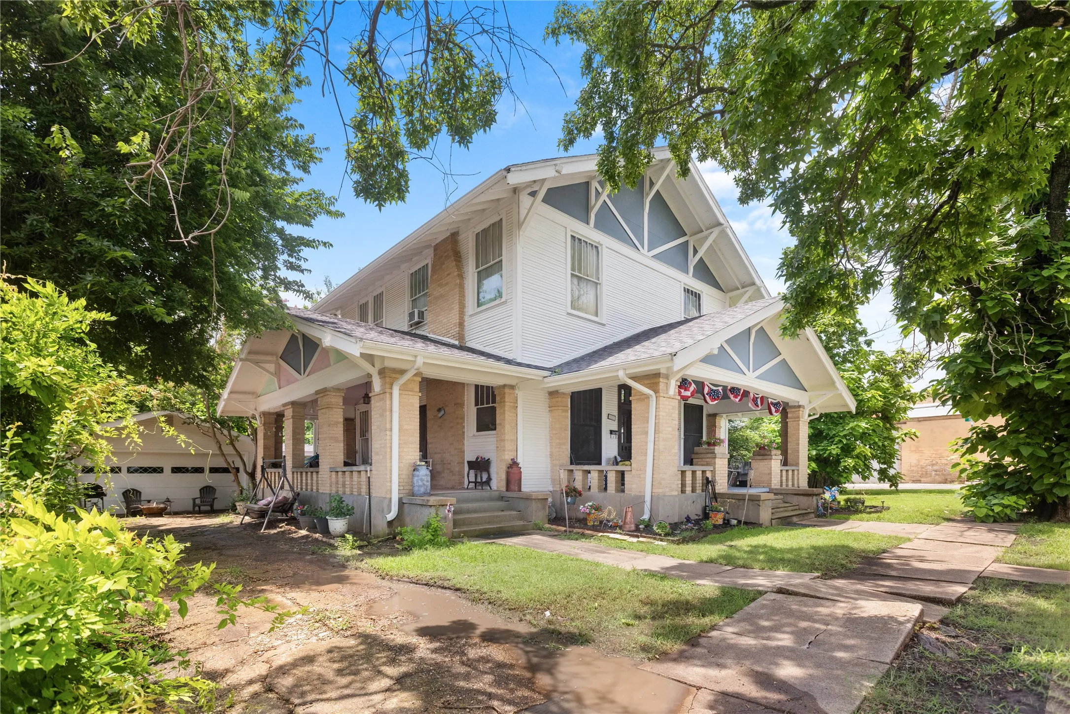 Two-story residence featuring a prominent gabled roofline with decorative trim and light blue accents