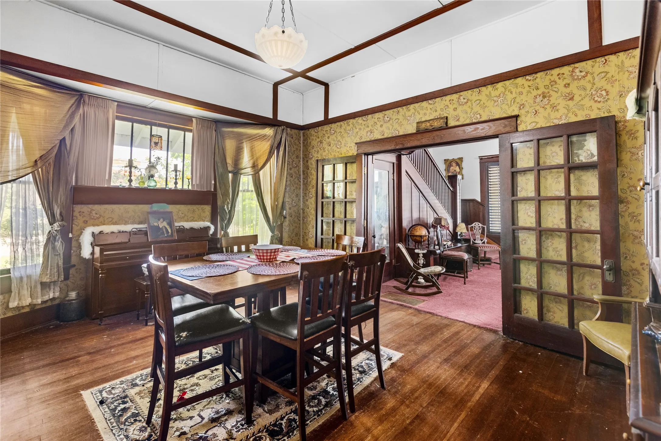 Spacious room featuring wood-finish flooring, decorative wallpaper, and wood trim detailing
