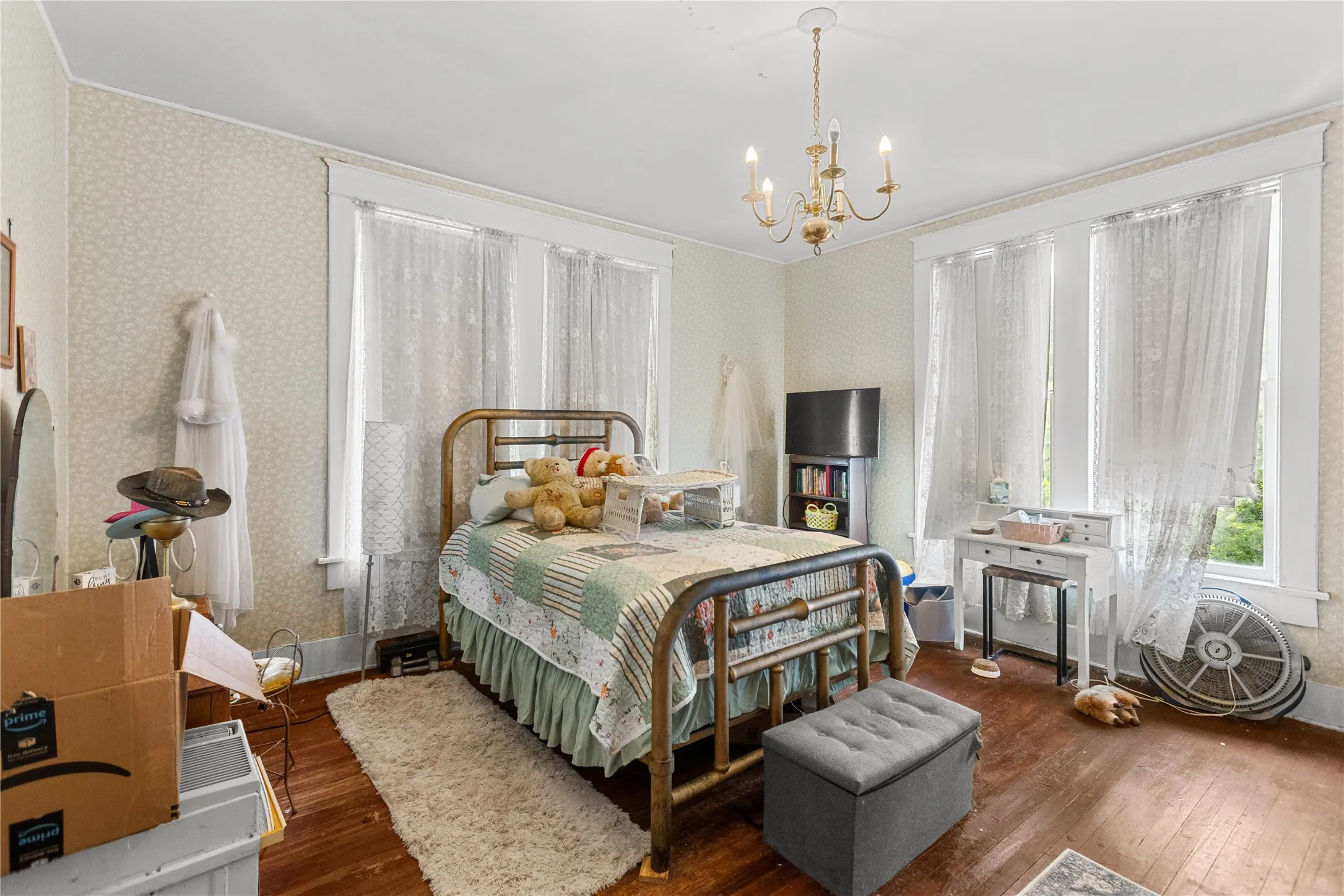 Hardwood flooring complemented by patterned wallpaper and white trim