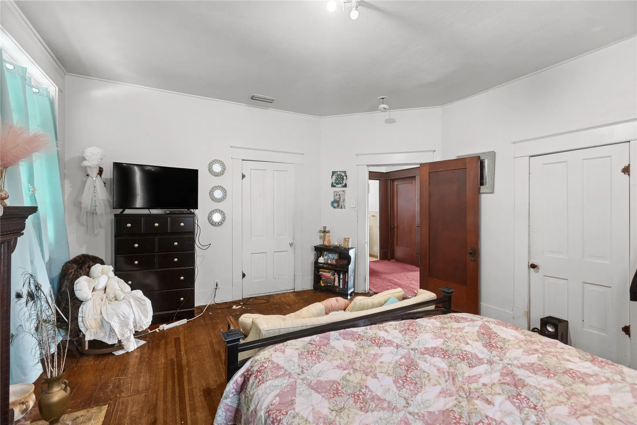 Interior room featuring wood-finish flooring, white walls, and bright overhead lighting