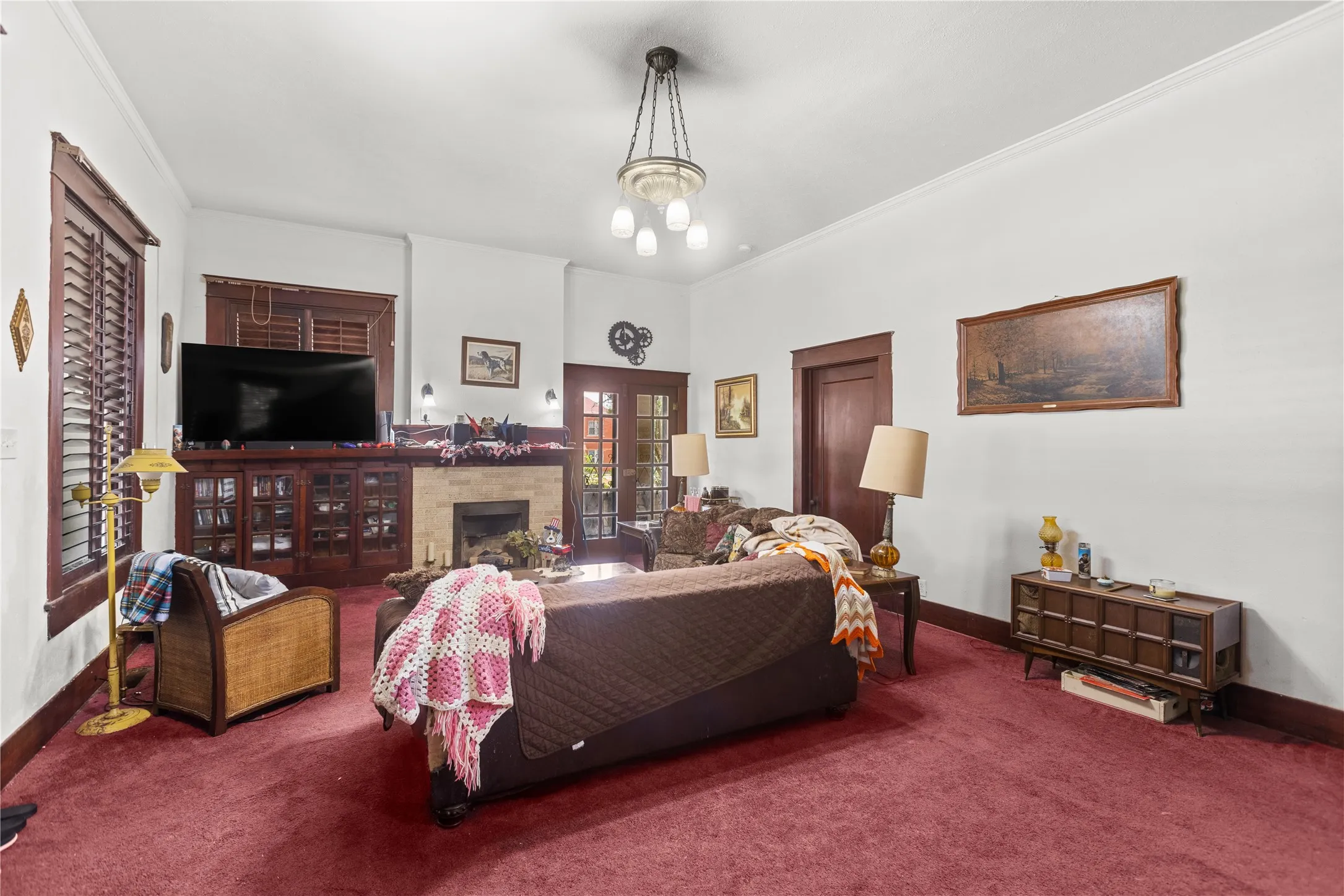 Spacious living area featuring rich wood trim, a stone-faced fireplace, and built-in cabinetry