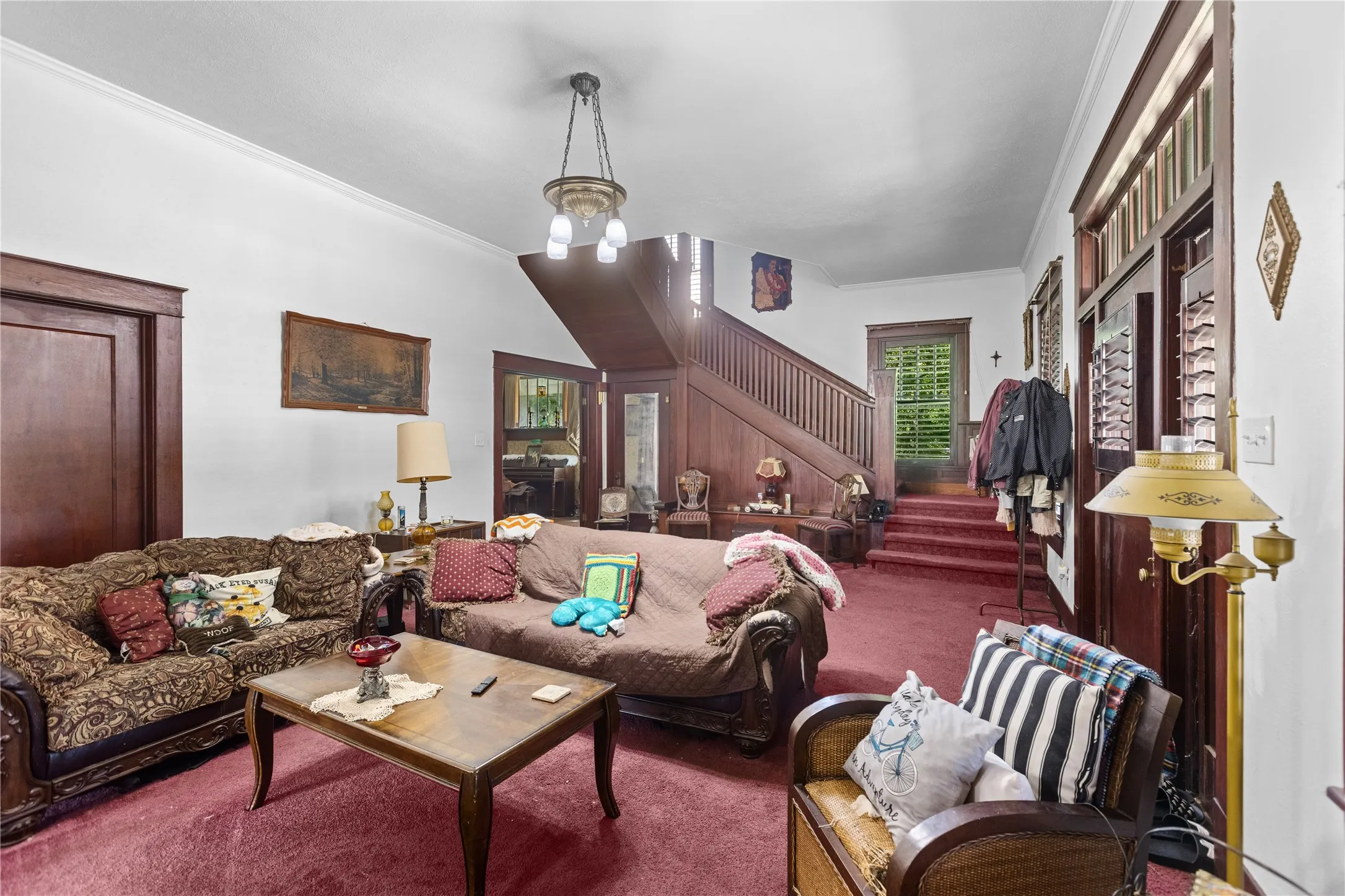 Spacious interior featuring a grand wooden staircase and rich wood trim throughout