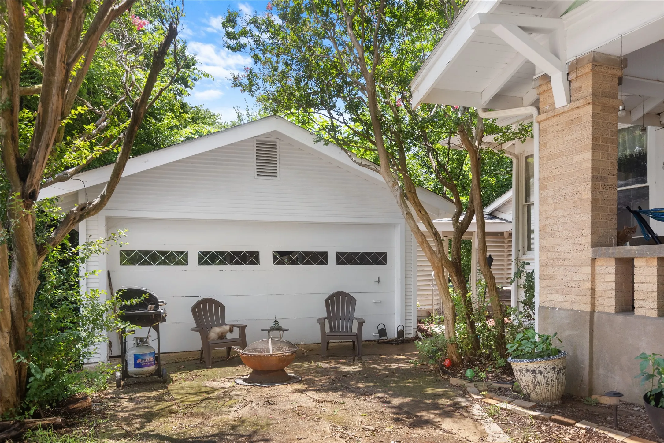 Detached white garage with horizontal siding and a gable roofline
