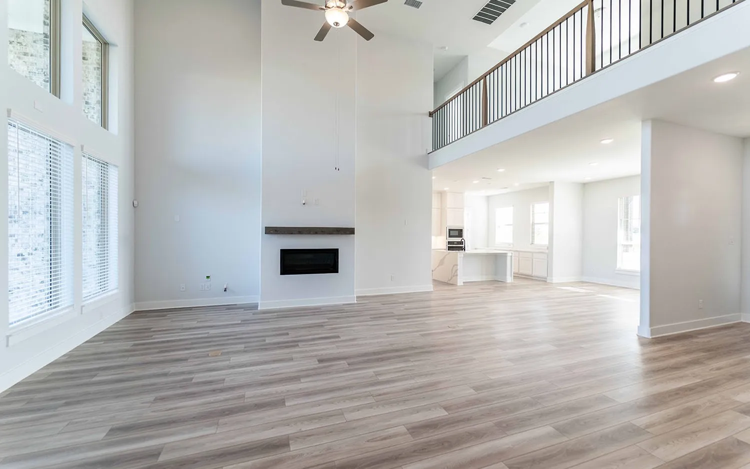 Two-story living area featuring wood-finish flooring and a ceiling fan
