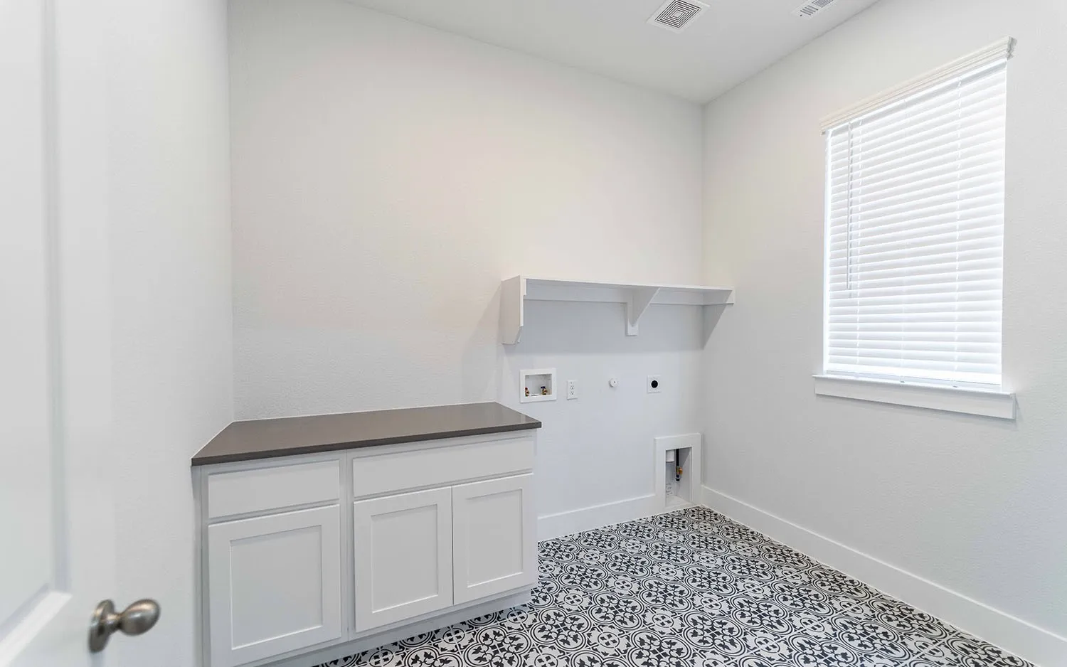 Utility room featuring patterned tile flooring