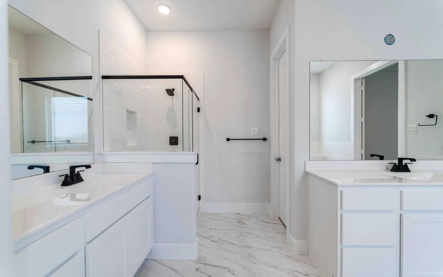 Bathroom featuring a dual vanity with white cabinetry and integrated sinks, complemented by matte black fixtures