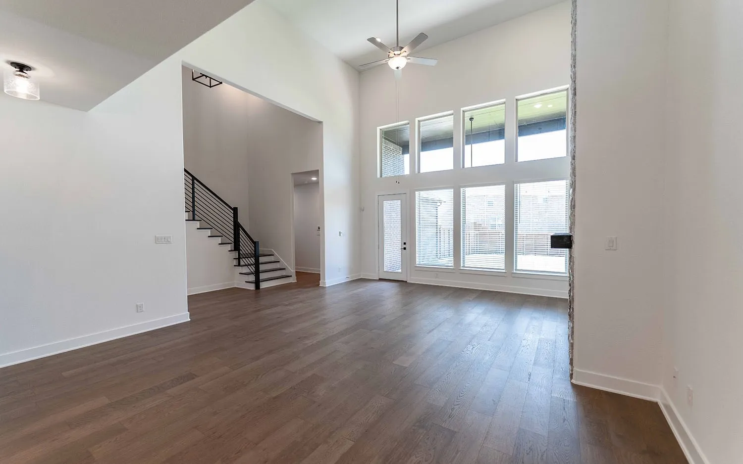 Spacious open-concept interior featuring high ceilings and wood-finish flooring