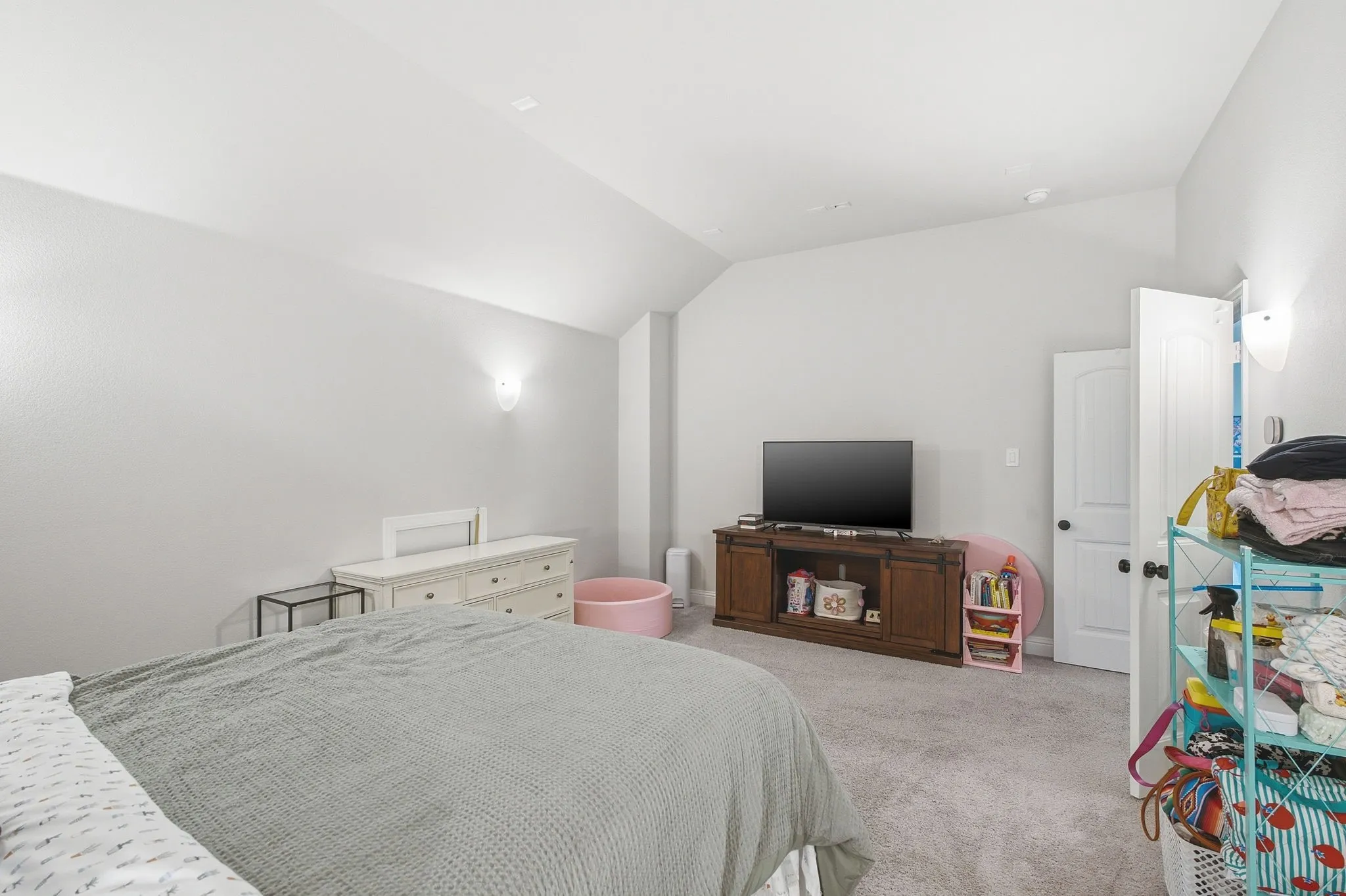 Carpeted interior space with sloped ceilings and light gray wall paint