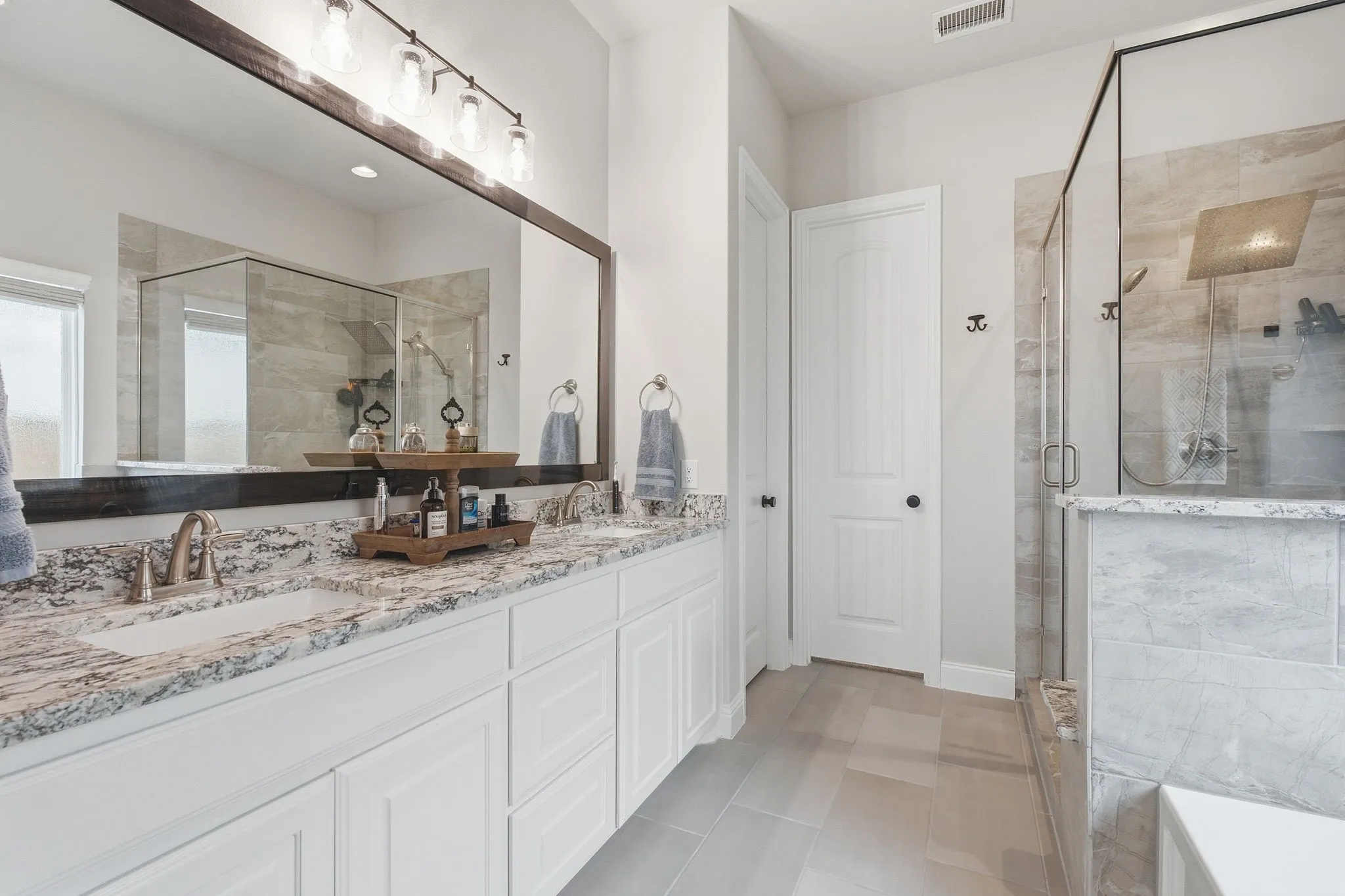 Double vanity with integrated sinks and brushed nickel faucets set in a granite countertop