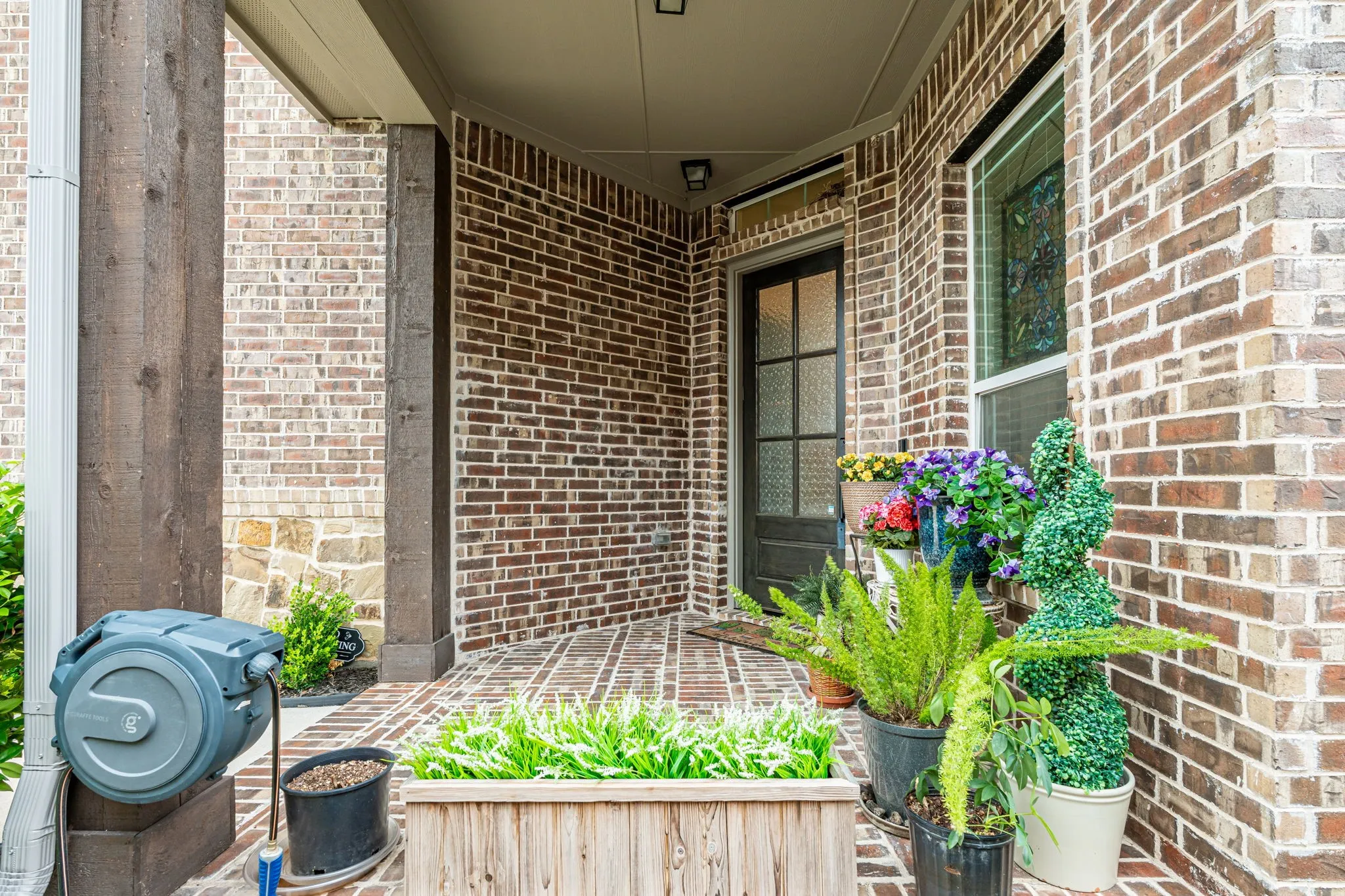 Brick exterior featuring stone accents and a covered front entry