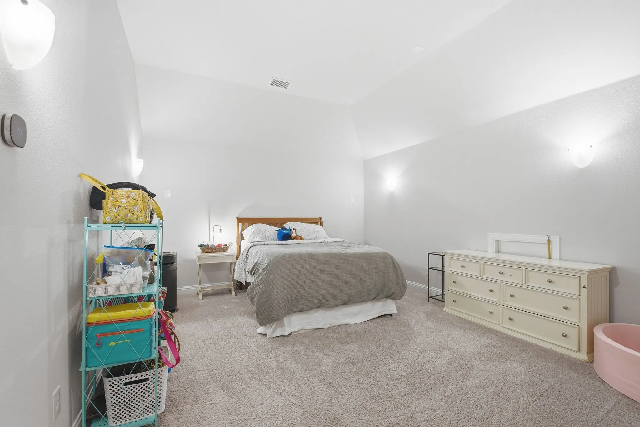 Carpeted room with vaulted ceilings and neutral wall color