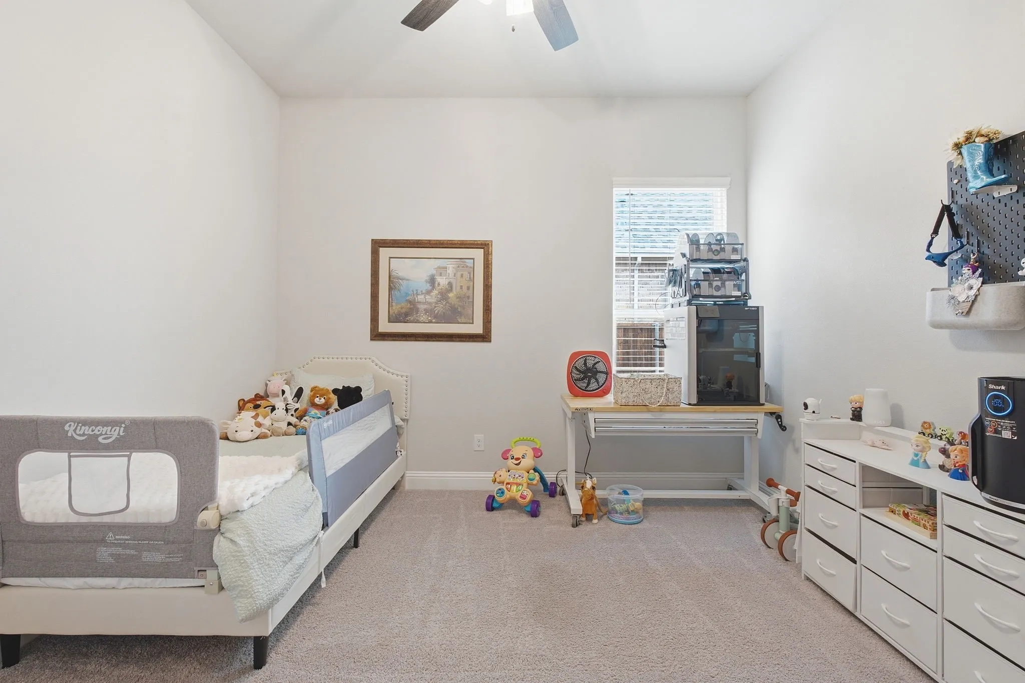 Neutral wall paint, ceiling fan, carpet flooring, a window with blinds, and built-in storage