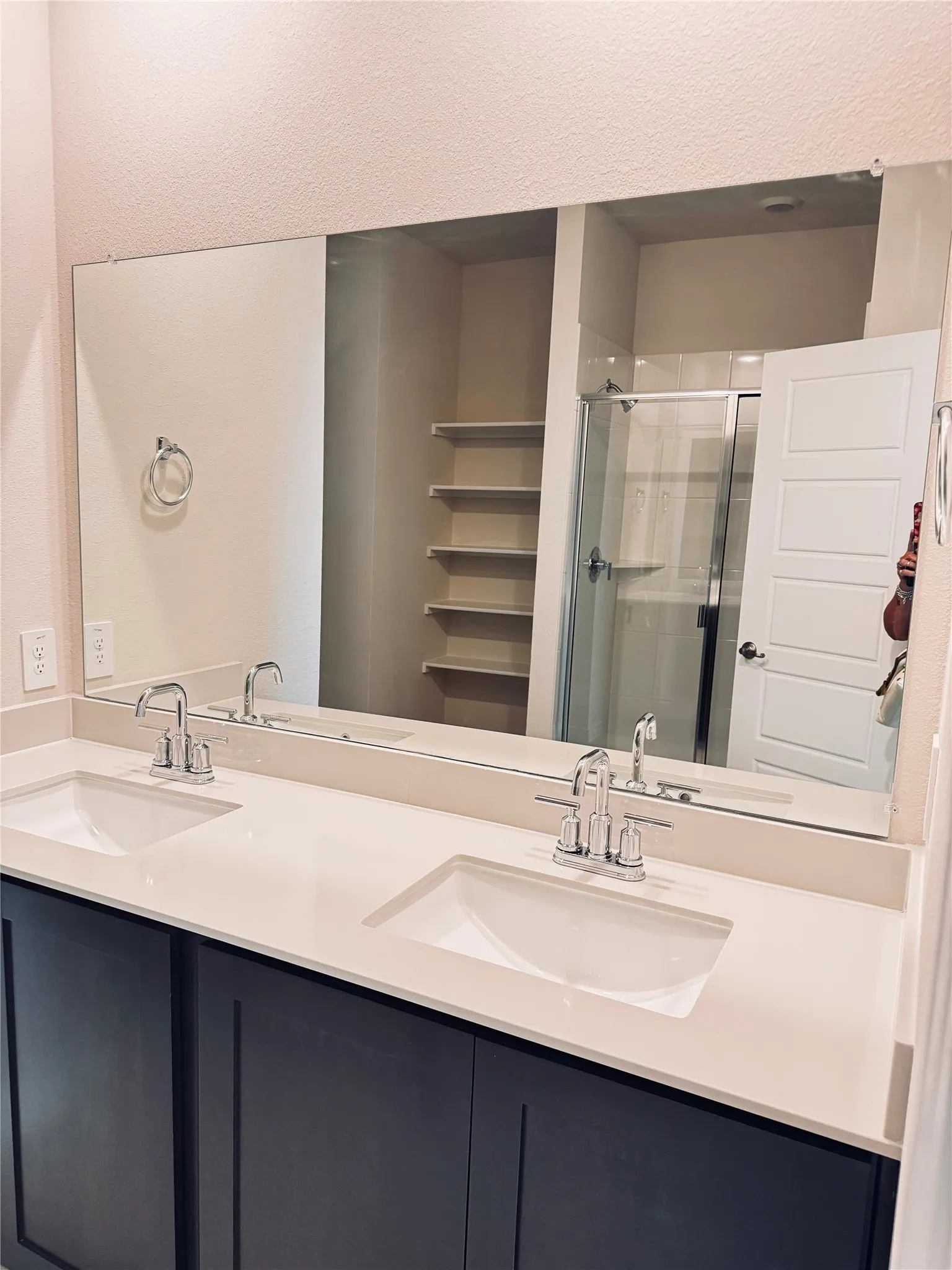 Dual sink vanity featuring dark cabinetry and light countertops