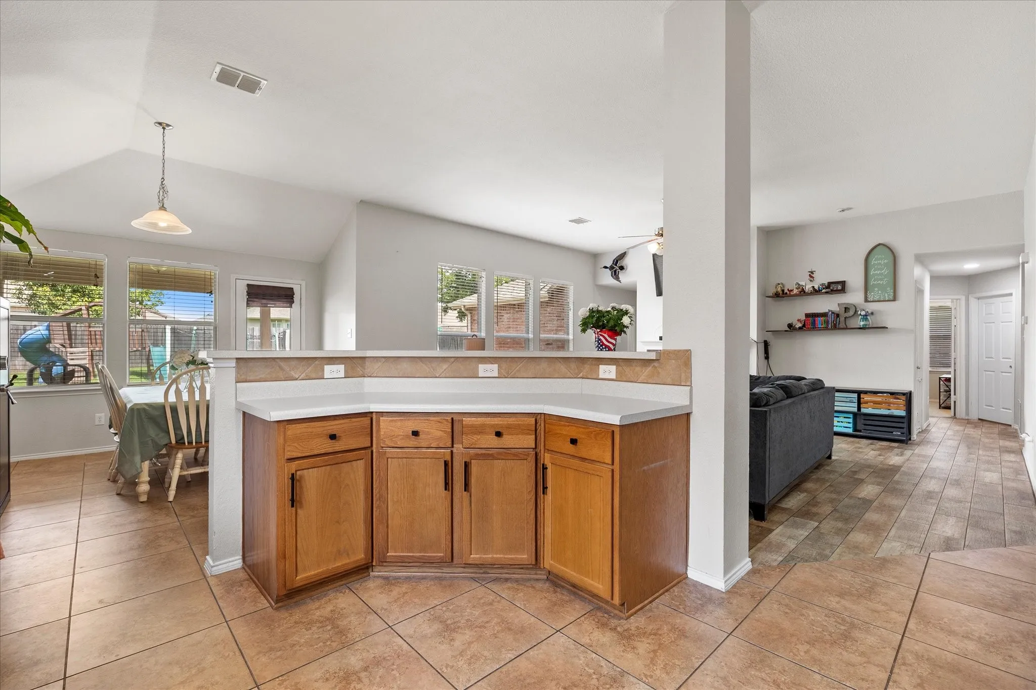 Kitchen peninsula with light-colored countertops and wood cabinetry
