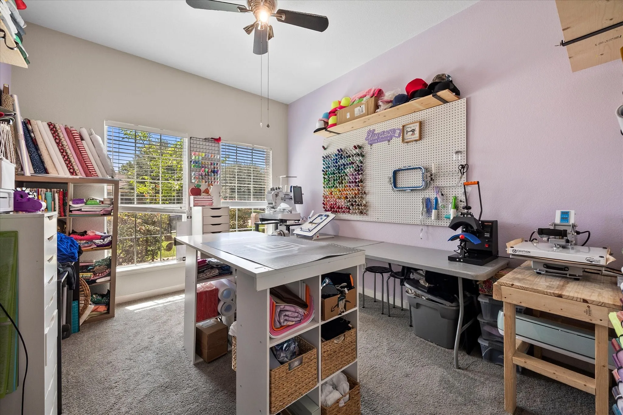 Room featuring two large windows, sloped ceiling, and a ceiling fan with light fixture