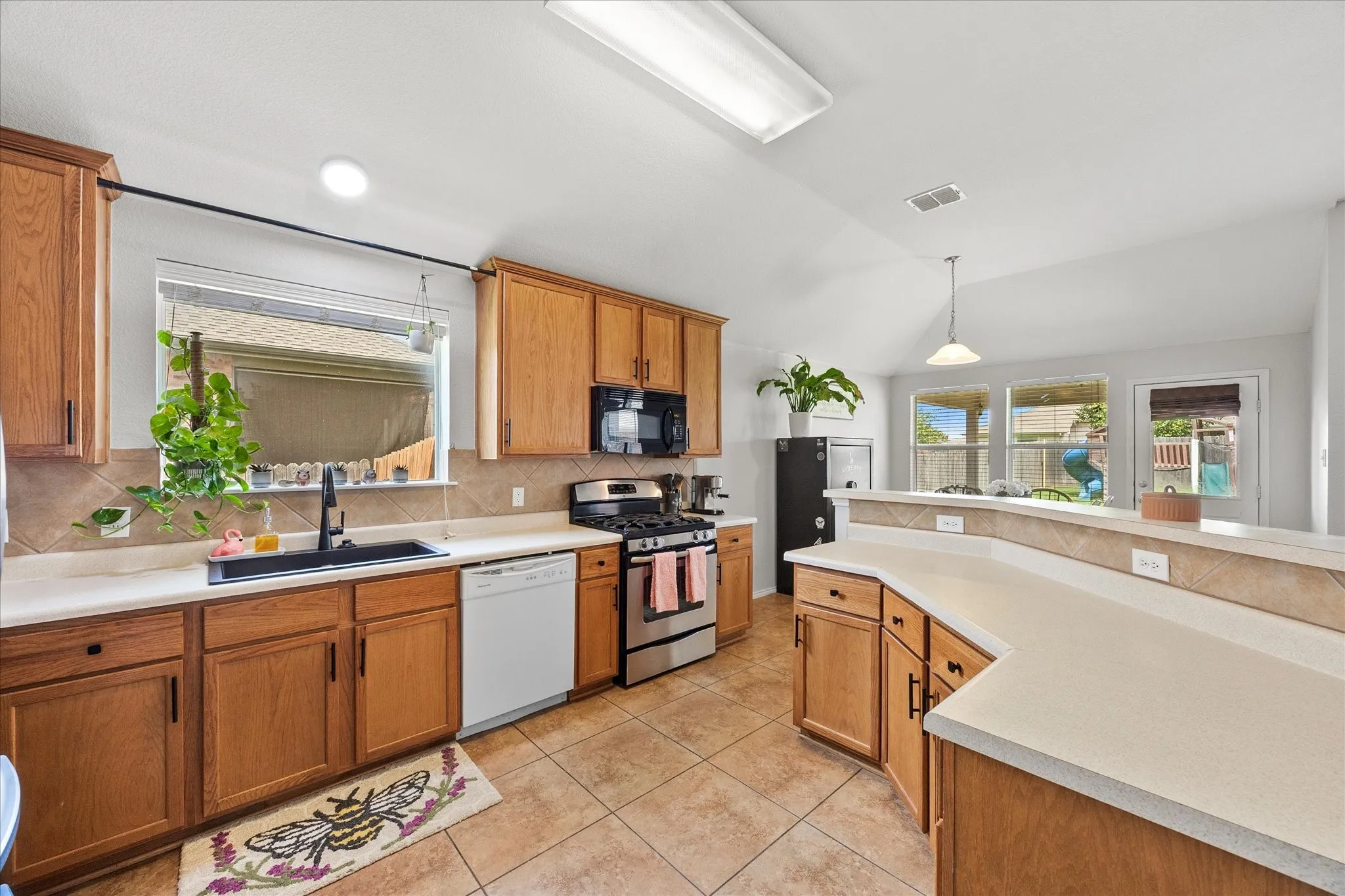 Kitchen featuring wood cabinetry, light-toned countertops, and tile flooring