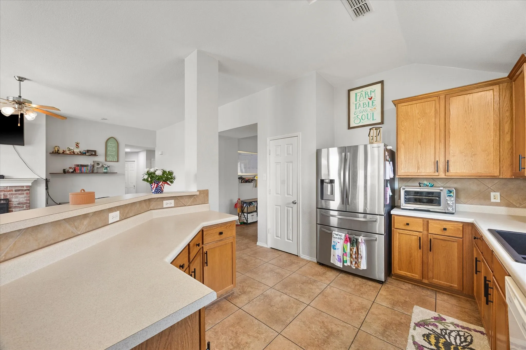 Kitchen featuring wood cabinetry, light-toned countertops, and a tile backsplash