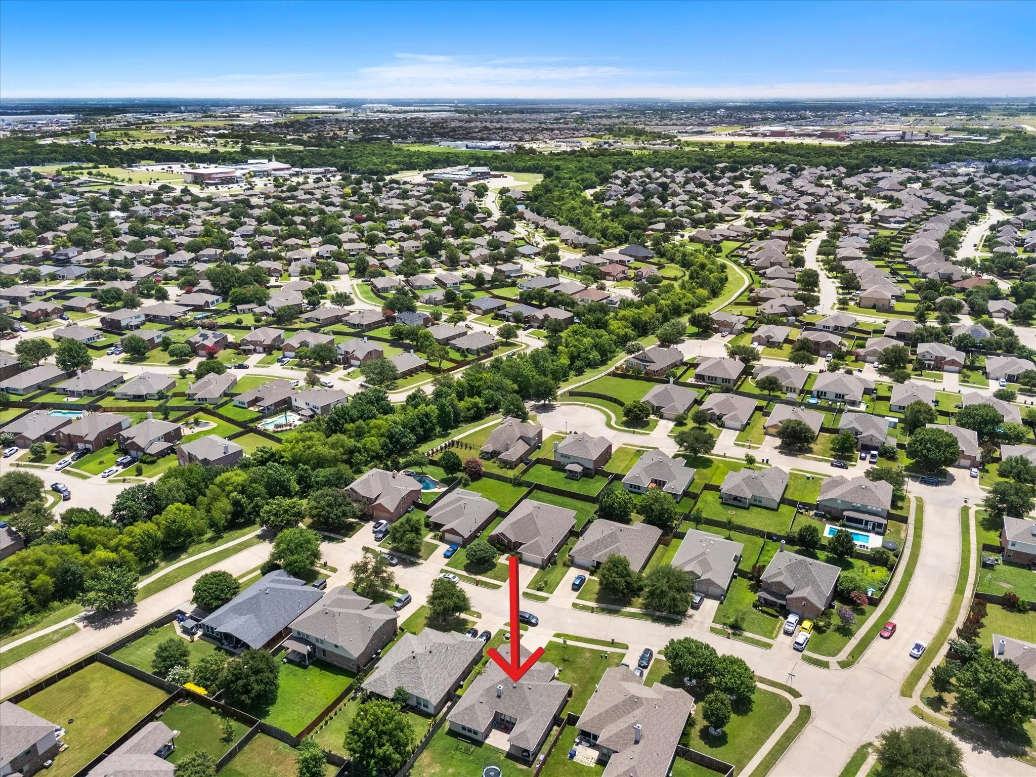 Aerial perspective of a residential neighborhood featuring numerous single-story homes with shingle roofs and green lawns