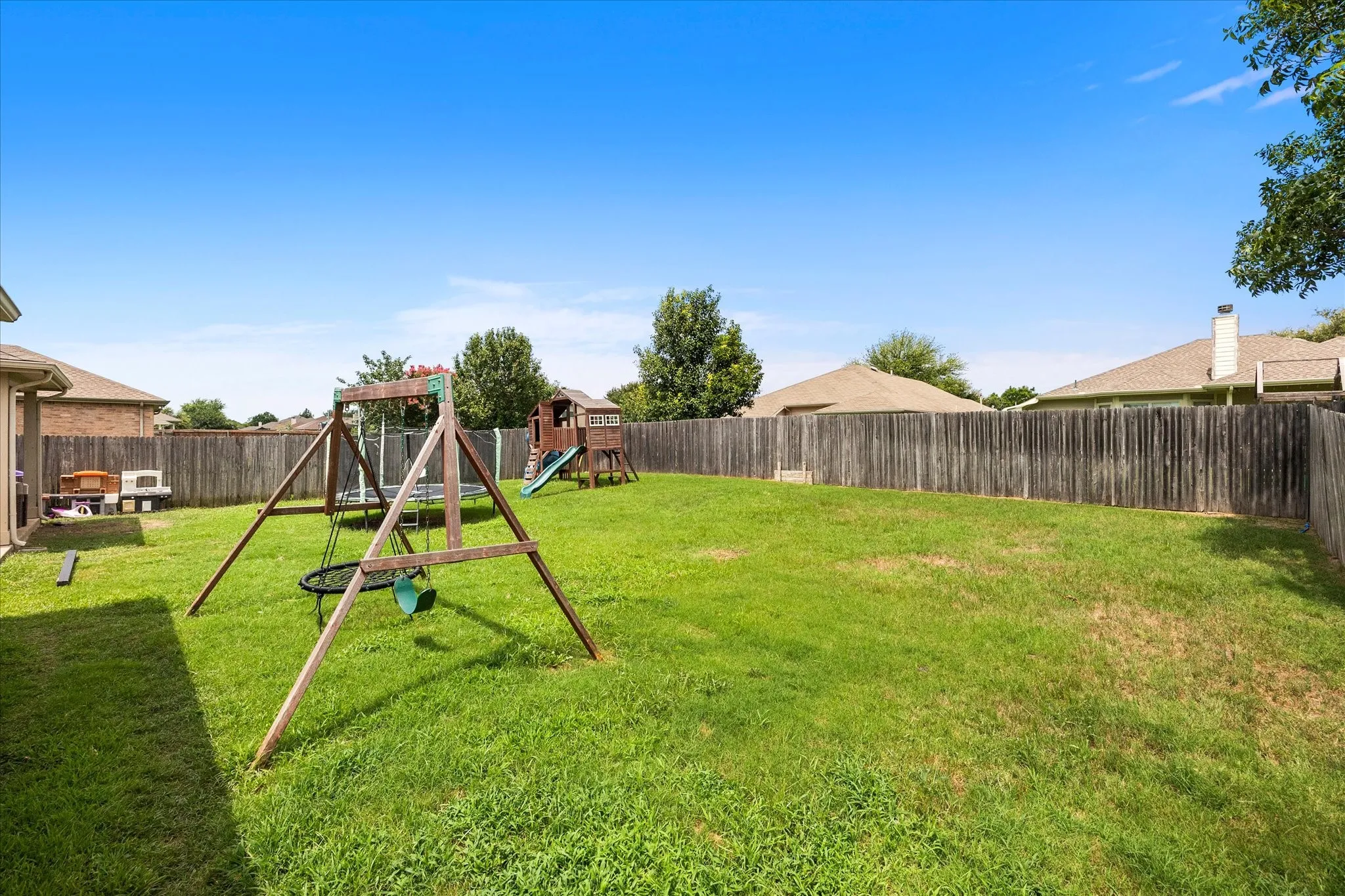 Expansive green lawn fully enclosed by a wood privacy fence