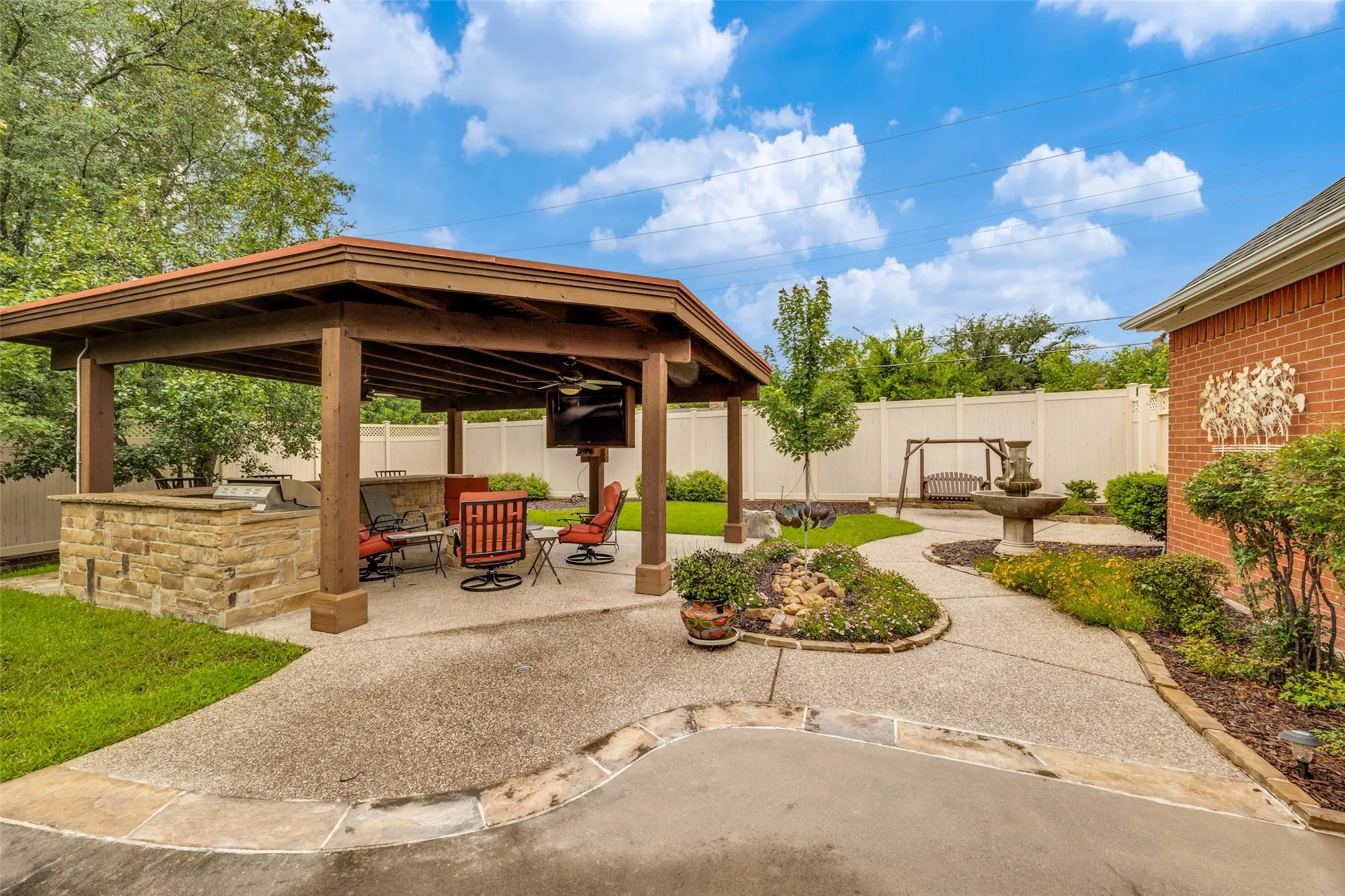 Back yard looking at outdoor living area and kitchen and back fence