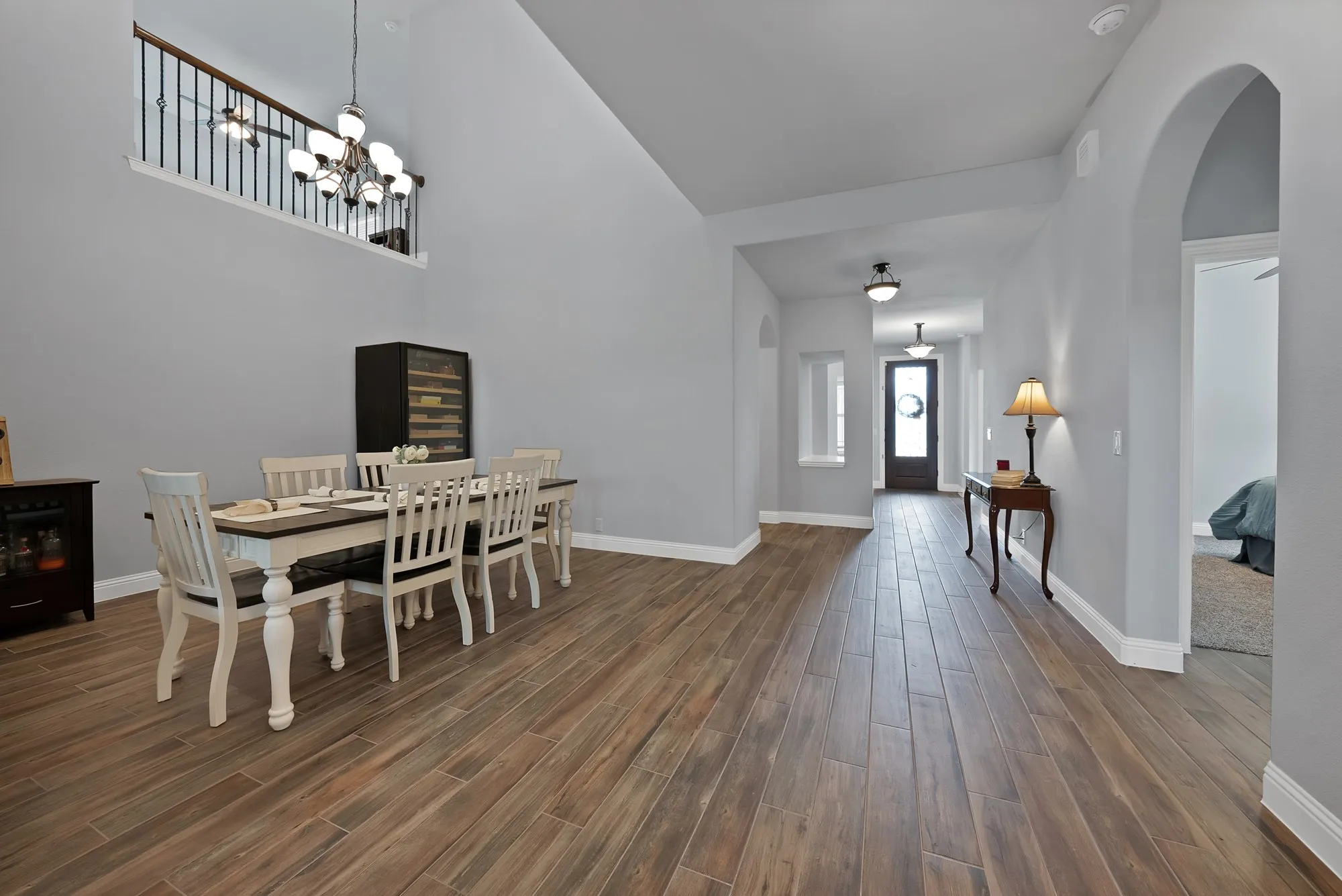 Expansive entry foyer and dining area featuring wood-finish flooring, high ceilings, and archway entries