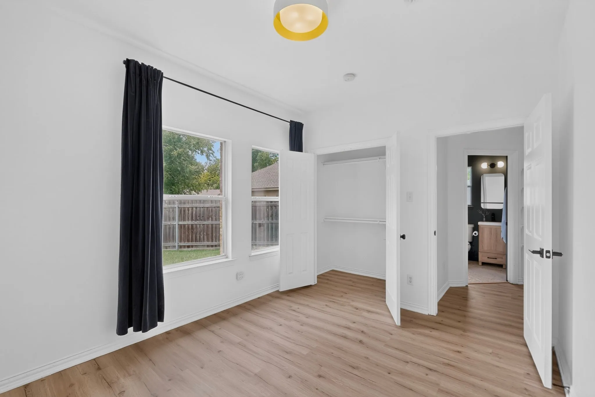 Room featuring wood-finish flooring, white walls, and crown molding