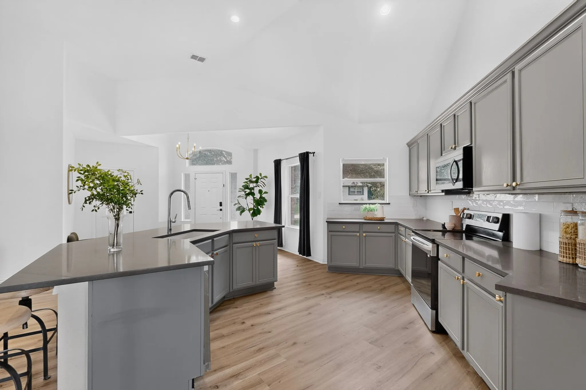Kitchen featuring light wood-finish flooring, vaulted ceilings, and recessed lighting