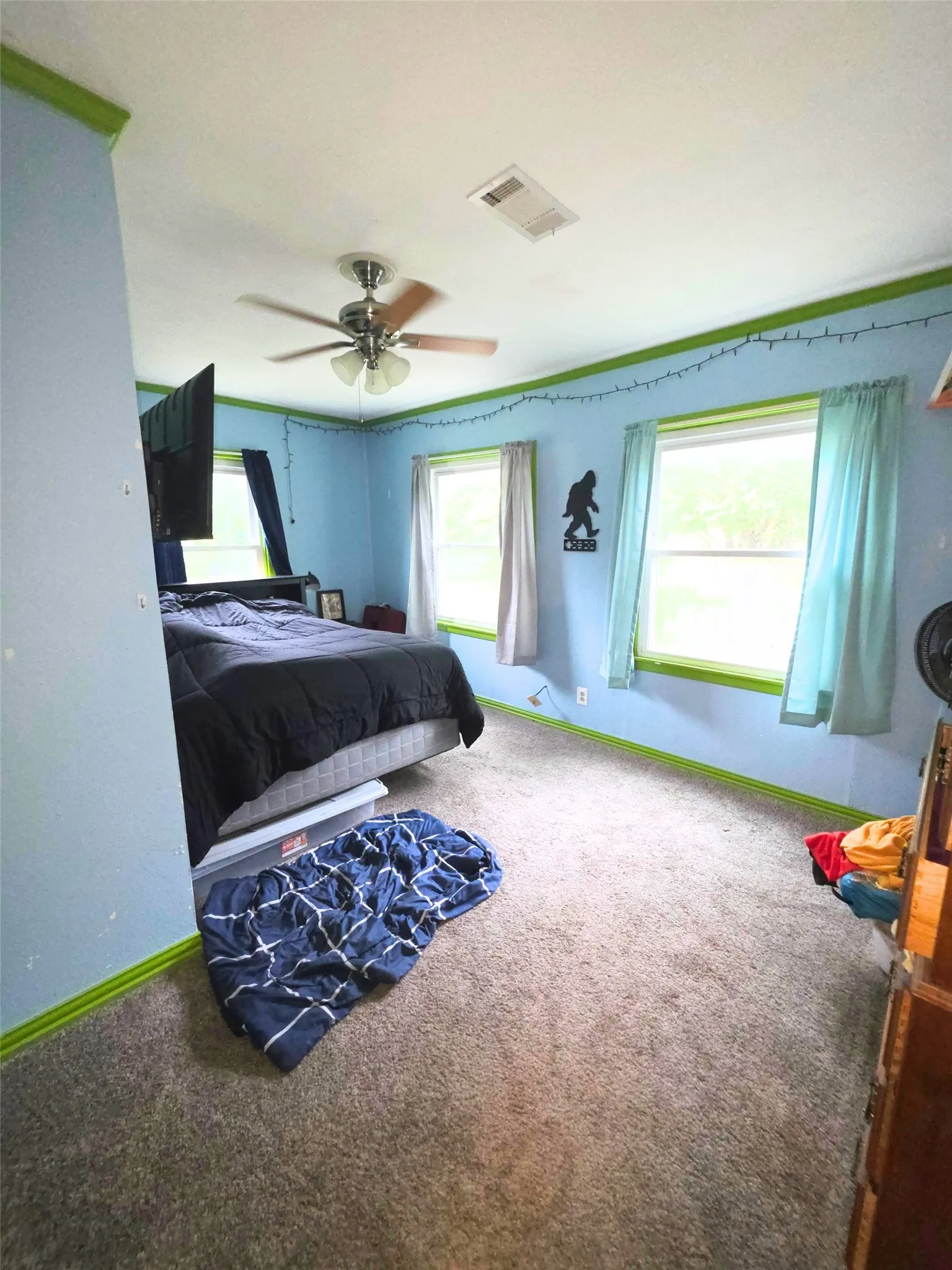 Carpeted room with a ceiling fan