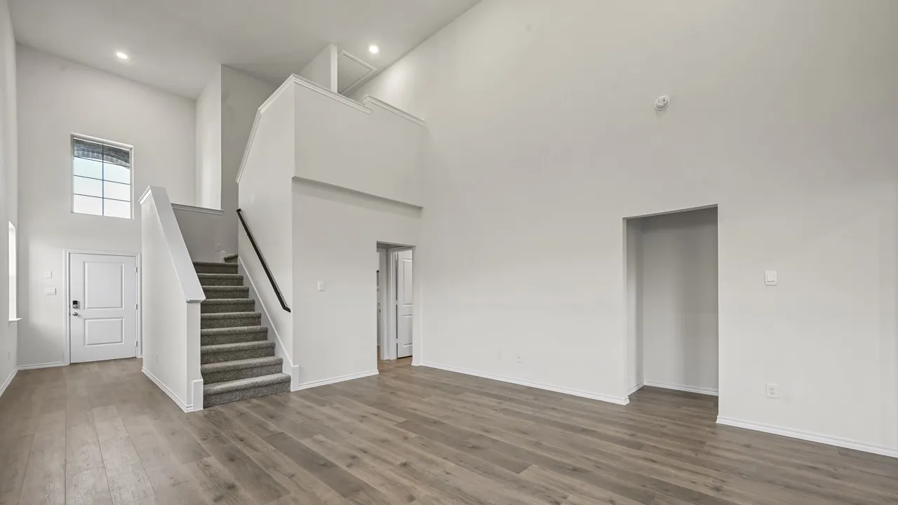 Expansive living area featuring soaring ceilings and wood-finish flooring