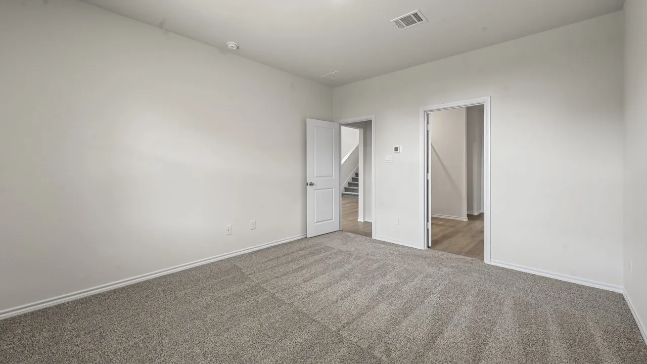 Spacious room featuring light gray carpet flooring and neutral wall tones