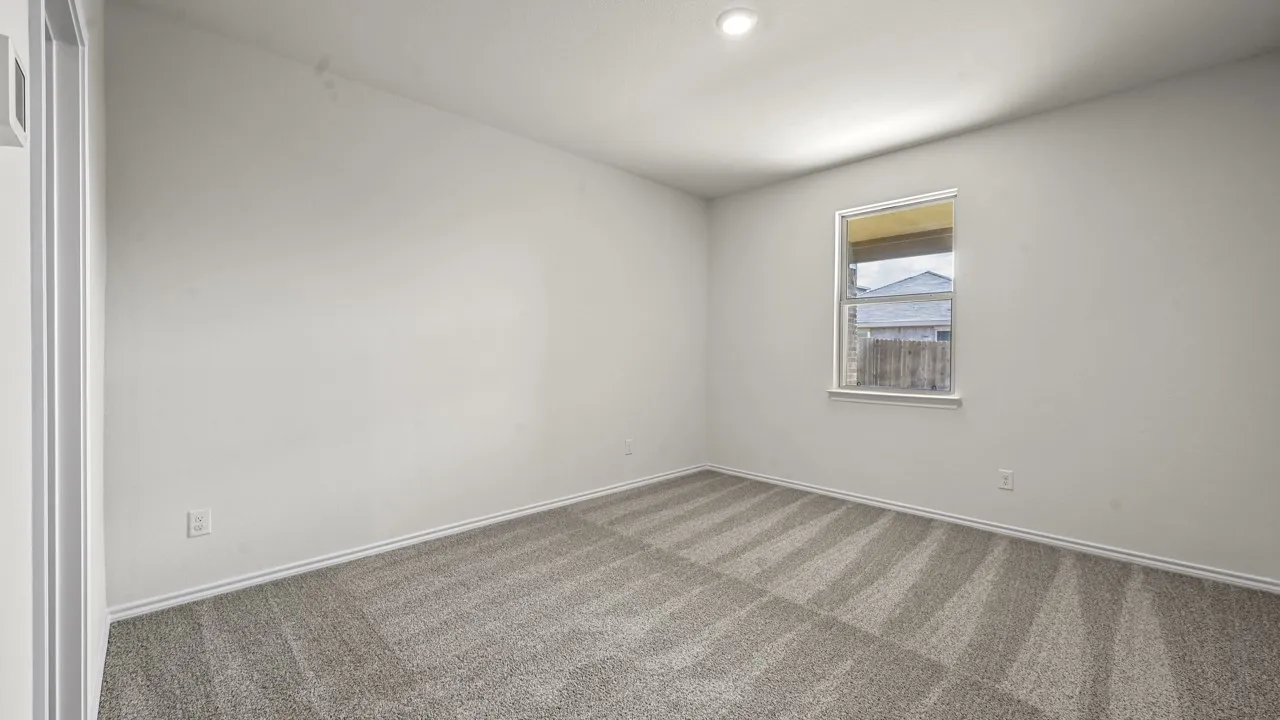 Room featuring light gray carpet with a subtle striped pattern, a single-pane window, and white baseboards