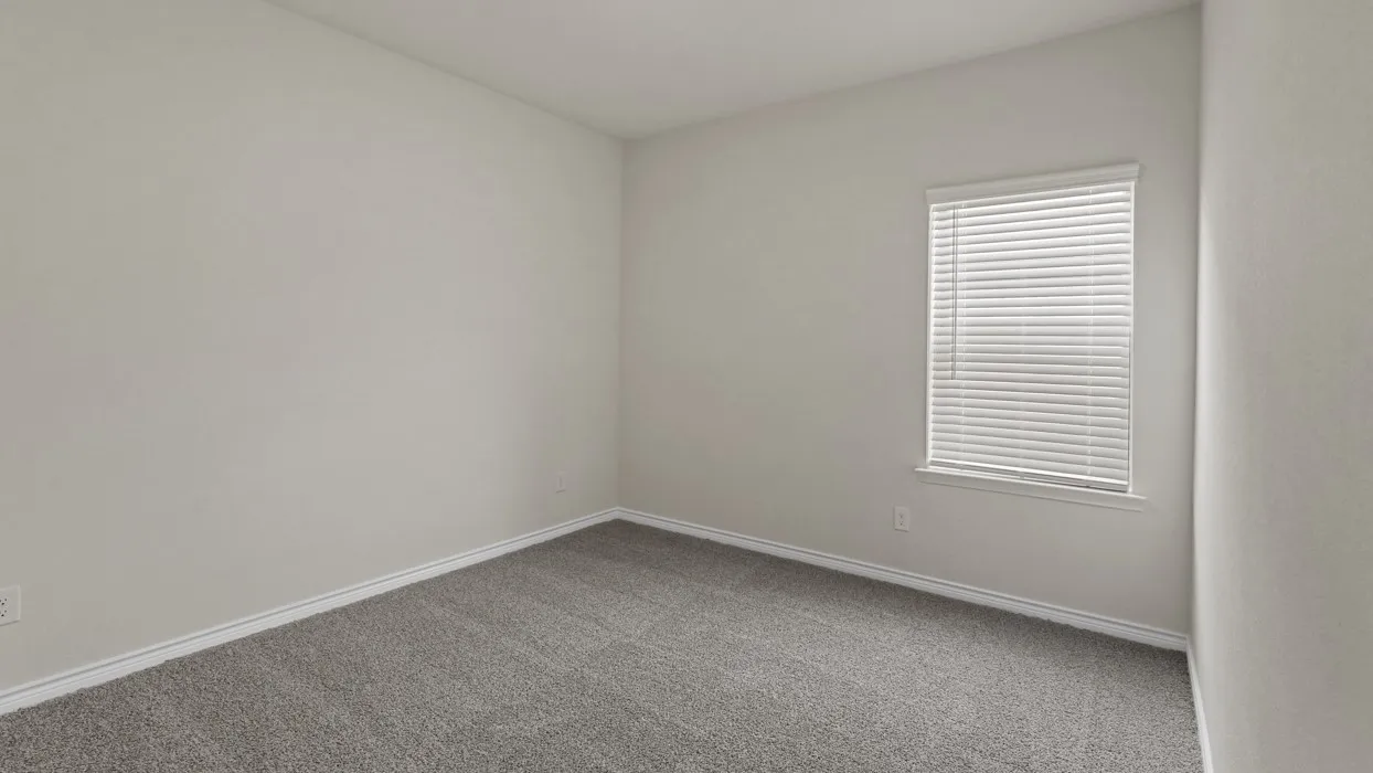 Neutral-toned room featuring a single window with blinds, light gray walls, and gray carpeting