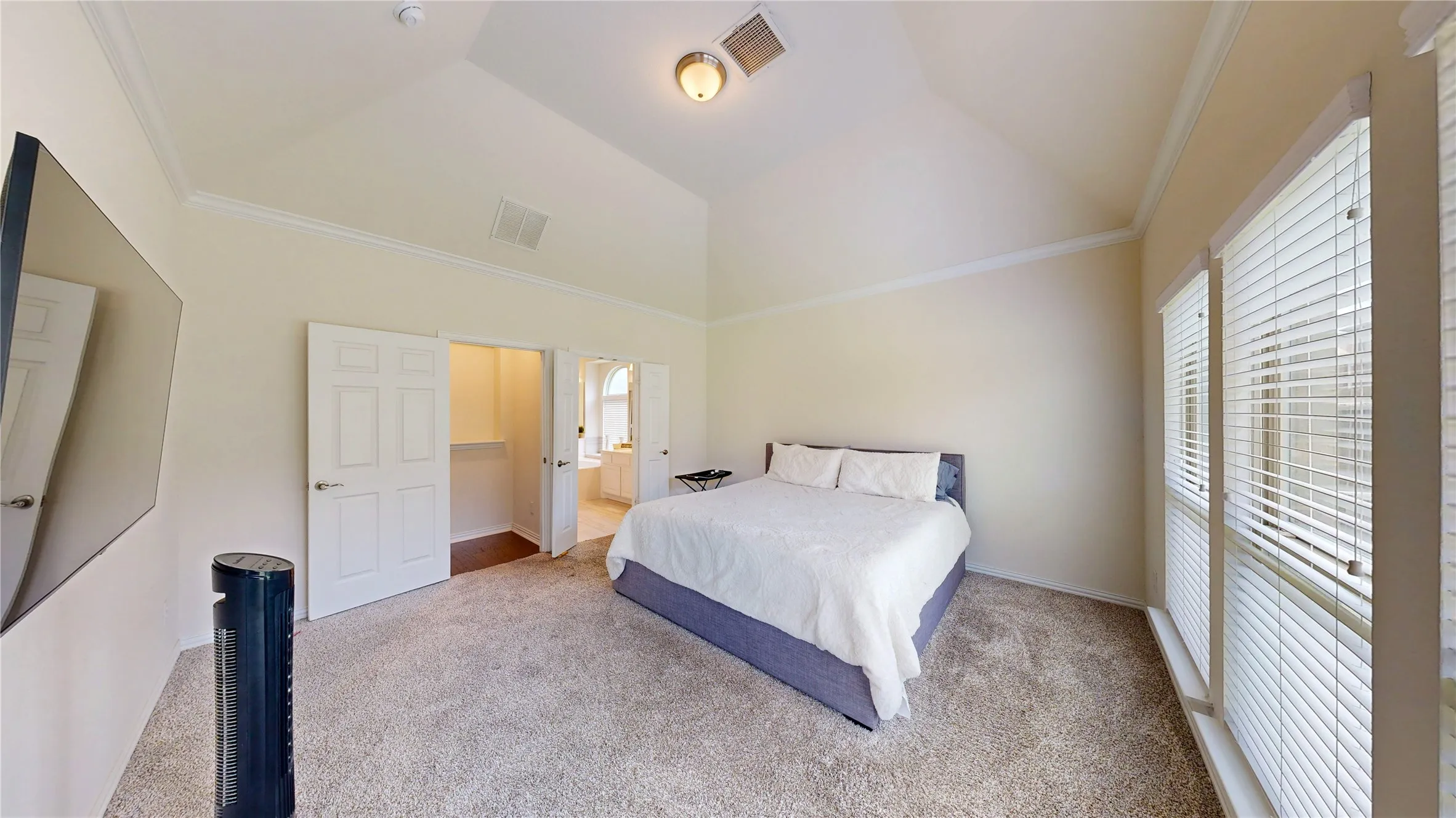 Vaulted ceiling room featuring carpet flooring and multiple windows with blinds